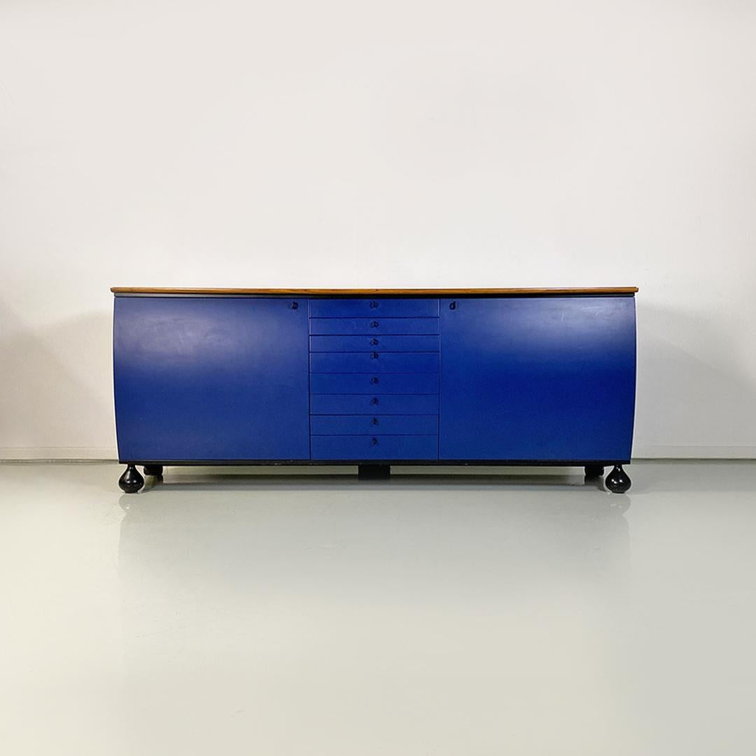 Italian post modern blue, black and wooden solid wood sideboard by Umberto Asnago for Giorgetti Italia, 1982.
Sideboard in solid wood, with a curved profile, composed of a row of central drawers of different heights, mirrored lateral hinged doors