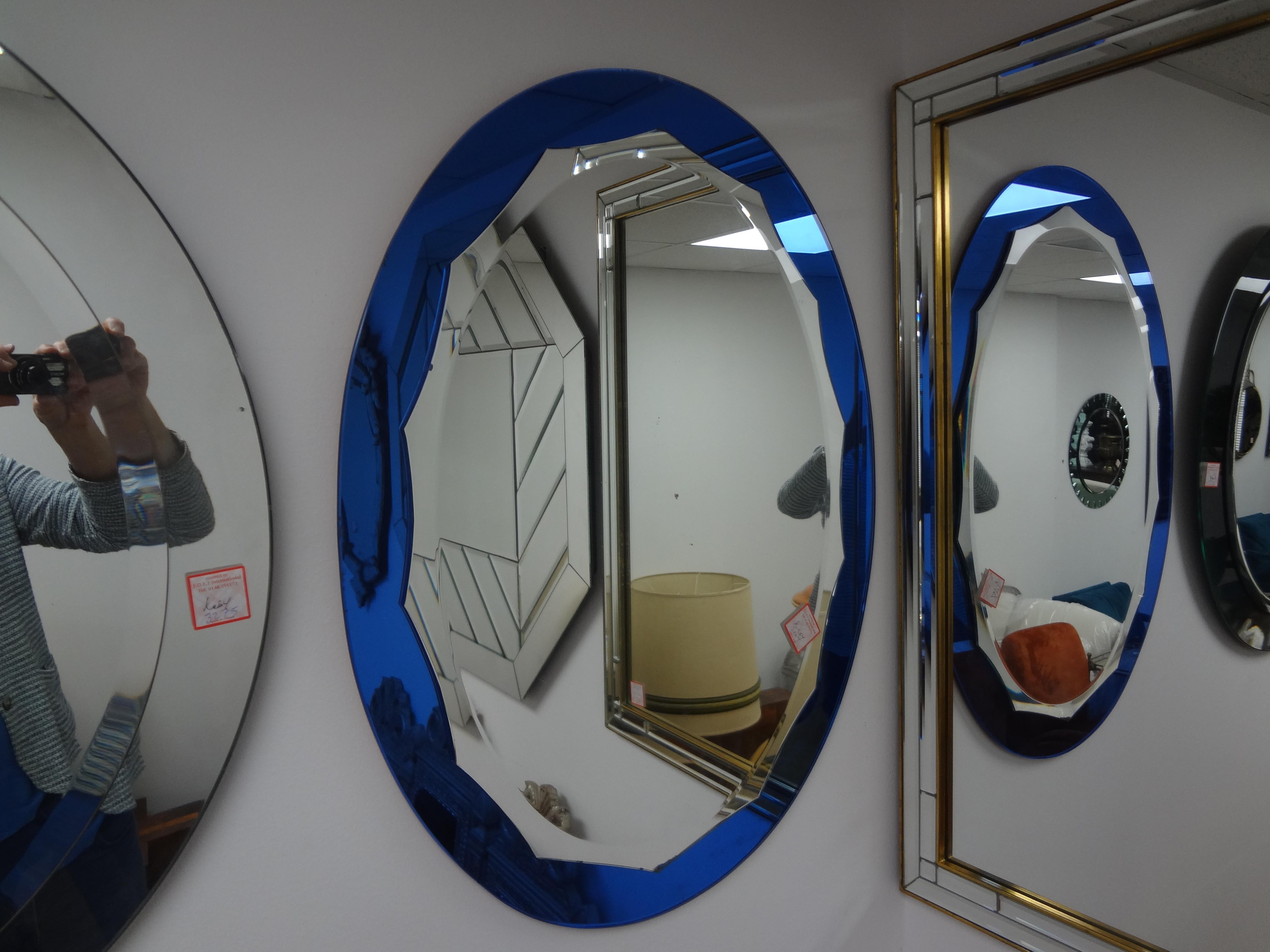  Italian Modern Blue Fontana Arte Style Beveled  Mirror .
This stylish Italian mid century oval mirror has a cobalt blue mirrored exterior with a scalloped silver beveled interior mirror.
Great Italian modern design and perfect for a powder room or