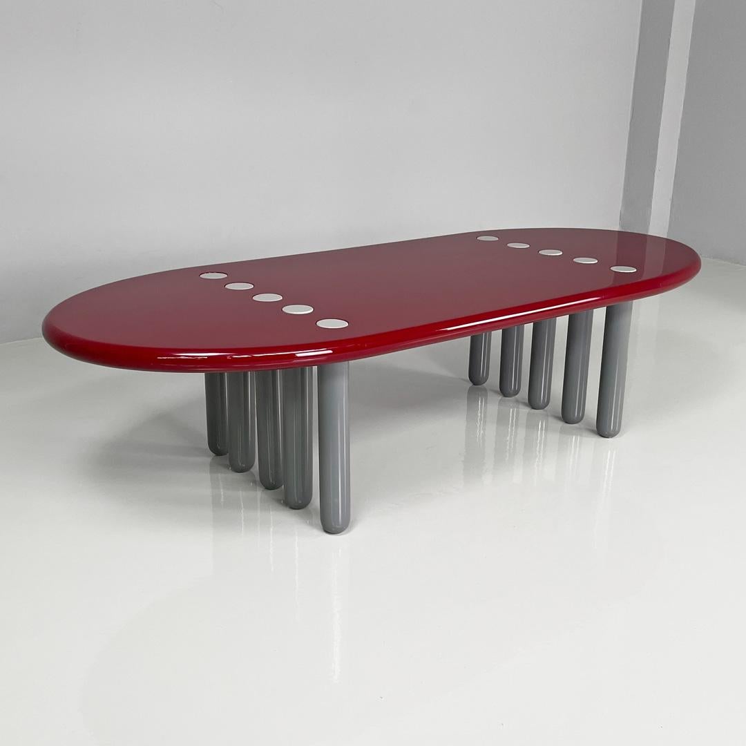 Table basse moderne italienne bordeaux laquée brillante avec pieds gris, années 1980
Table basse entièrement en bois laqué bordeaux brillant avec dix pieds gris.
Le plateau est ovale et comporte des cercles blancs correspondant aux pieds de section