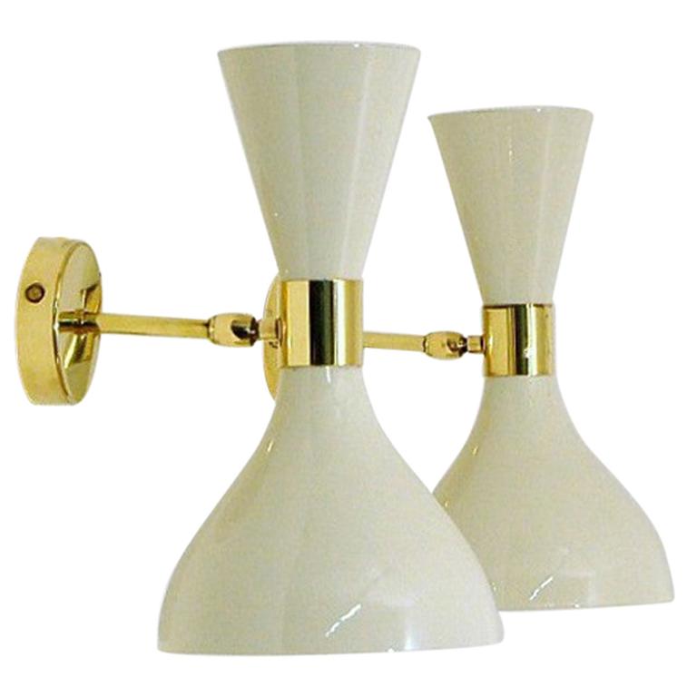The wall sconce or reading light shown in unlacquered natural brass and white enamel fabricated in Italy by Fabio Ltd. 

The cones are a vintage 1950s Italian design. Swiveling head allows for cone adjustment. This design is strongly influenced by