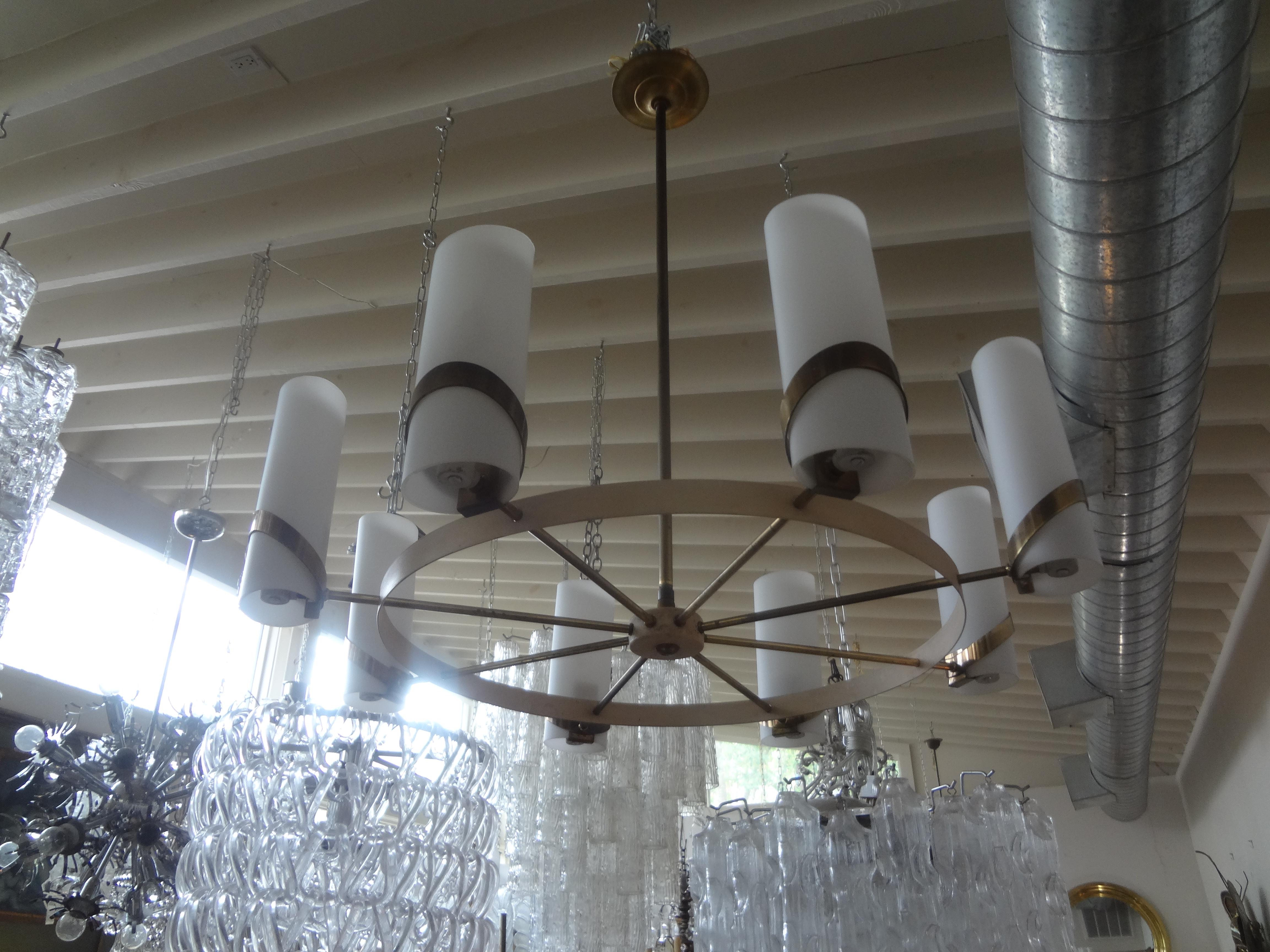 Italian Modern brass and glass chandelier.
This simple but stunning Italian Mid-Century Modern chandelier is made of brass with 8 beautiful opaline glass shades. The height of center rod can be increased or decreased as needed.