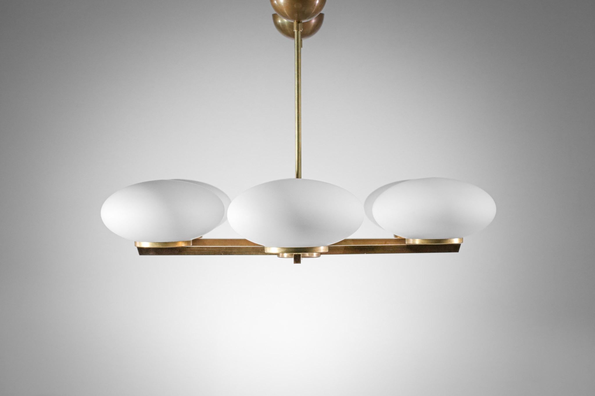 Imponente lampadario italiano contemporaneo in ottone e opalina bianca, composto da una solida struttura in ottone e da una fila di sei grandi opaline ovoidali in vetro opaco. Design moderno realizzato dai nostri artigiani italiani, finitura in