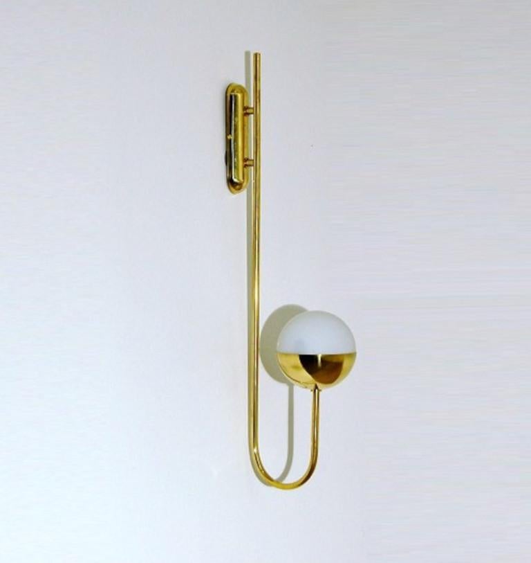 Elegant wall light shown in unlacquered natural brass with opaline milky glass globe fabricated in Italy by Fabio Ltd. 

This is a modern, contemporary interpretation of a classic wall light, strongly influenced by Italian Mid-Century Modernism such