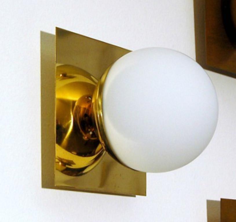 Elegante lampada da parete o da incasso in ottone lucido con globo in vetro opalino lattiginoso prodotta in Italia da Fabio LTD. 

Si tratta di un'interpretazione moderna e contemporanea di un'applique classica, fortemente influenzata dal modernismo