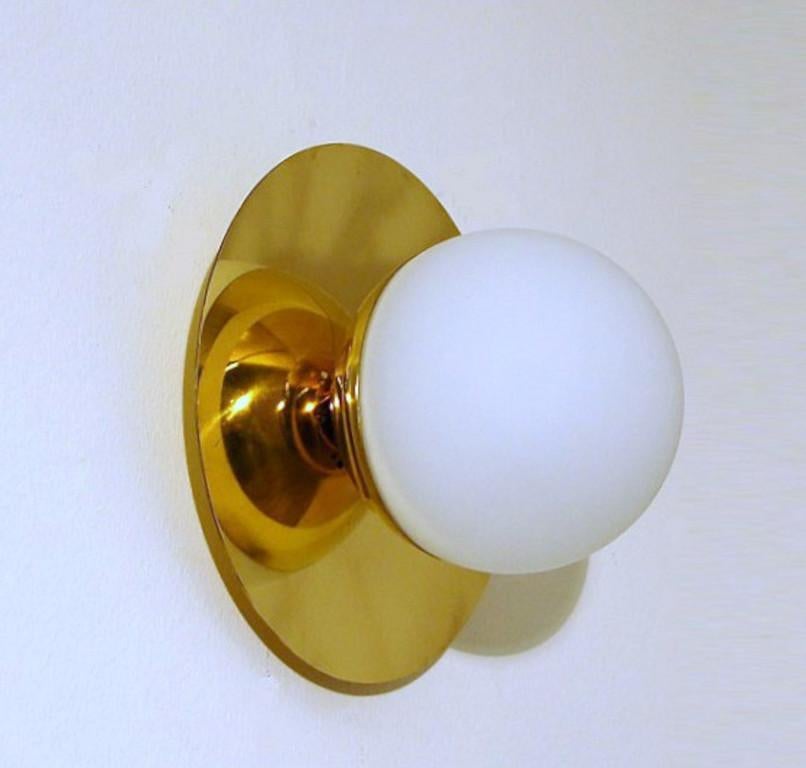 Elegant wall light or flush mount shown in polished brass with opaline milky glass globe fabricated in Italy by Fabio Ltd. 

This is a modern, contemporary interpretation of a classic wall light, strongly influenced by Italian Mid-Century Modernism