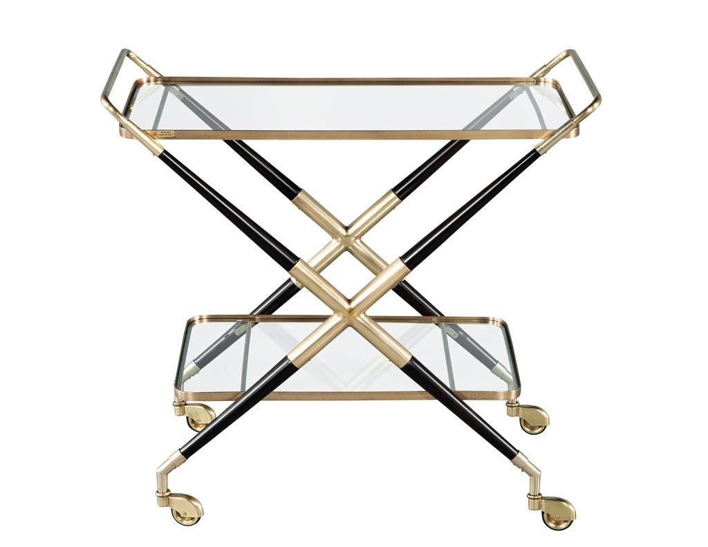 Ce superbe chariot de bar vintage, conçu par le légendaire Gio Ponti, incarne l'essence du modernisme italien des années 1960. Fabriquée en Italie, cette pièce présente une combinaison frappante de laiton, de bois teinté noir et de verre