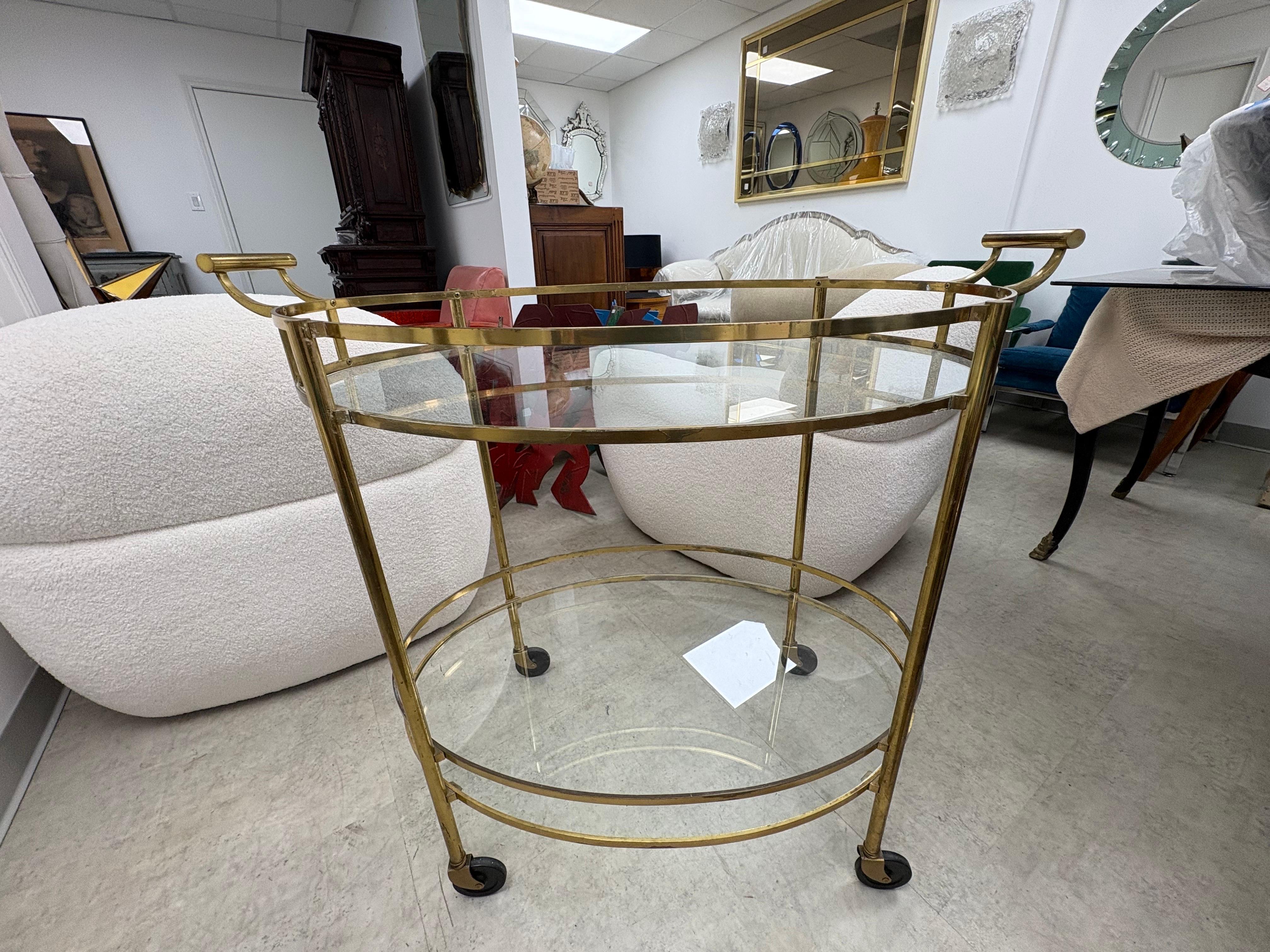Chariot de bar moderne italien en laiton.
Nous vous proposons un beau chariot de service, chariot de bar ou trolley en laiton à deux niveaux de style Hollywood Regency.
Ce chariot ovale fonctionnel est grand et comporte deux étagères en verre. Il
