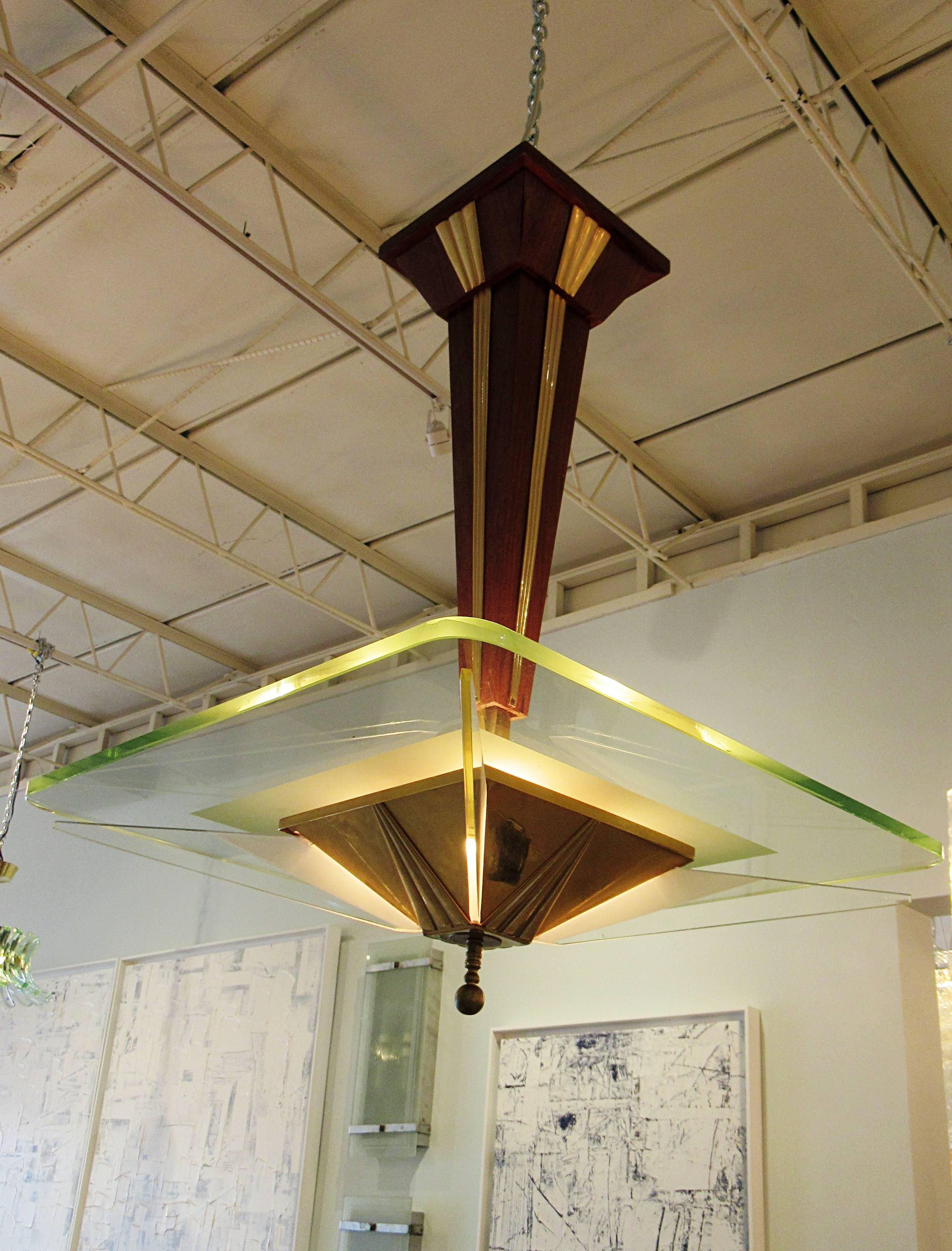 Brass inlaid walnut central tapering support with polished brass accents meeting a square glass slab light source, with each corner having fin shaped glass cut-glass, meeting a pyramidal brass and walnut central light source
Literature: Fontana