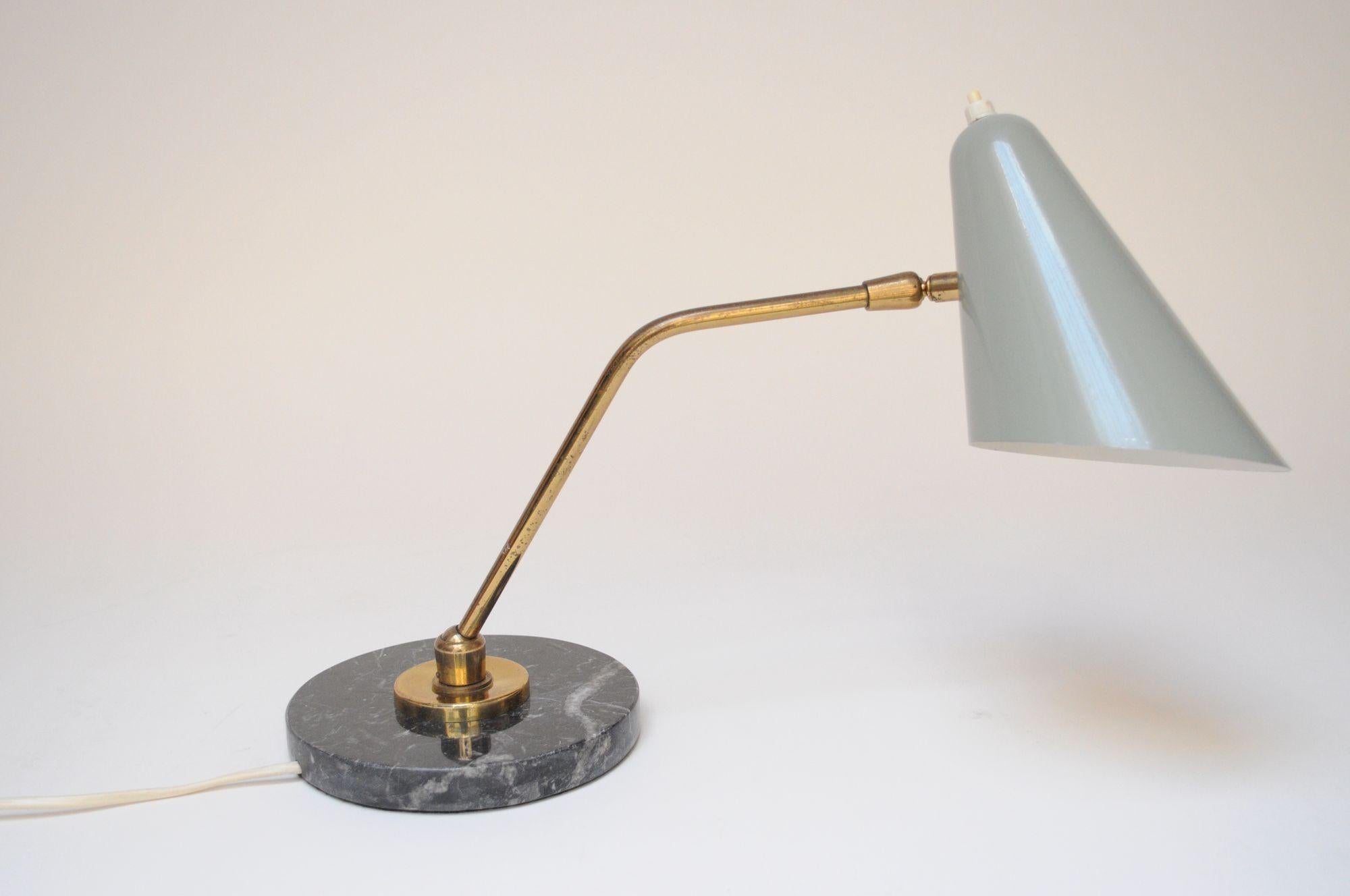 Elegant articulating table lamp by Luci Milano (ca. 1950s, Italy)
Composed of a brass pivoting stem and adjustable gray metal conical shade, all supported by a round, black marble base.
Light wear present - scuff and small spot of paint loss to the