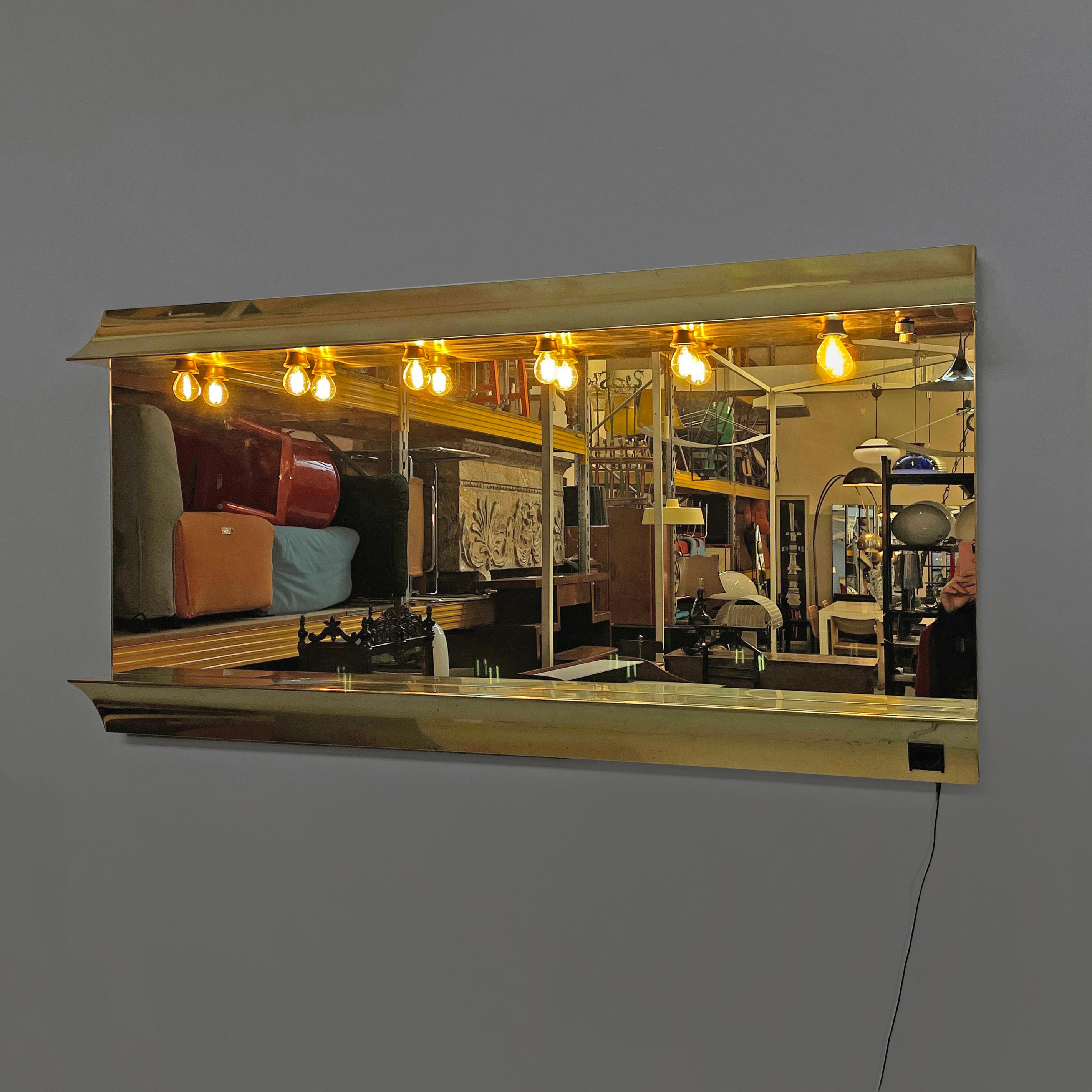 Italian modern brass wall mirror with six lamps, 1980s
Wall mirror with embossed brass frame. On the upper profile there are six lamps and the round metal switch. In the lower part there is a power socket.
1980s
Good condition, light scattered marks