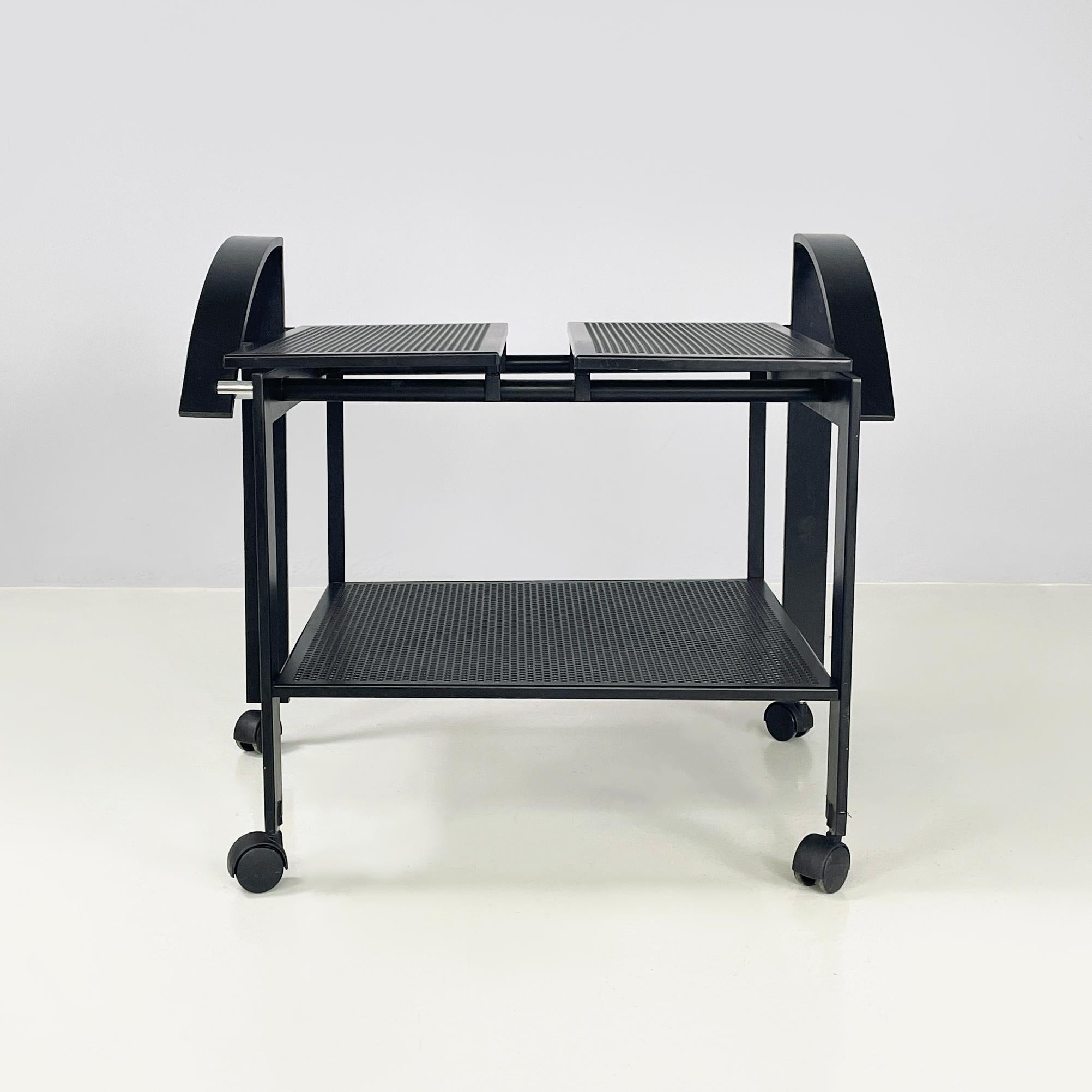 Carrito moderno italiano con 2 tableros de metal perforado negro, años 80
Carro con doble estante rectangular perforado con agujeros redondos, totalmente de metal pintado de negro. La parte superior está dividida en dos partes y se apoya en una