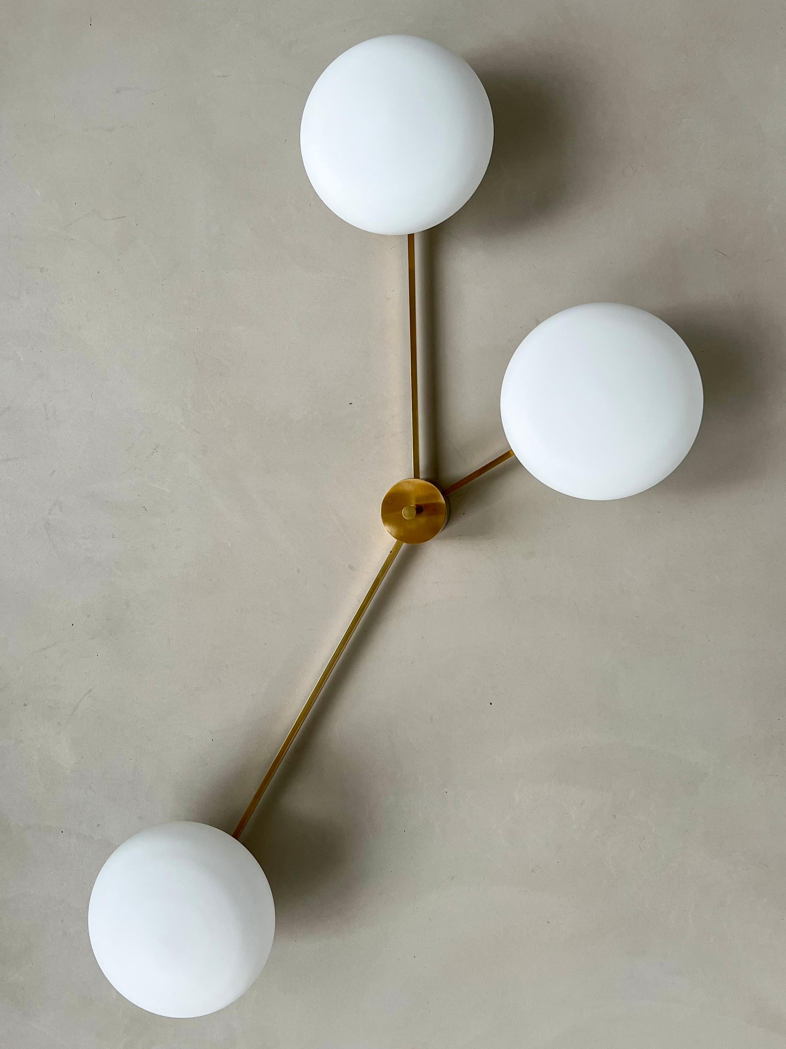 Vintage Mid Century Italian Chandelier

Chandelier / ceiling light in brass with three arms and three opaline glass shades. Has a nice patina developed over time. It measures 135cm by 85cm, and when mounted has an overall depth of 30cm. It is in