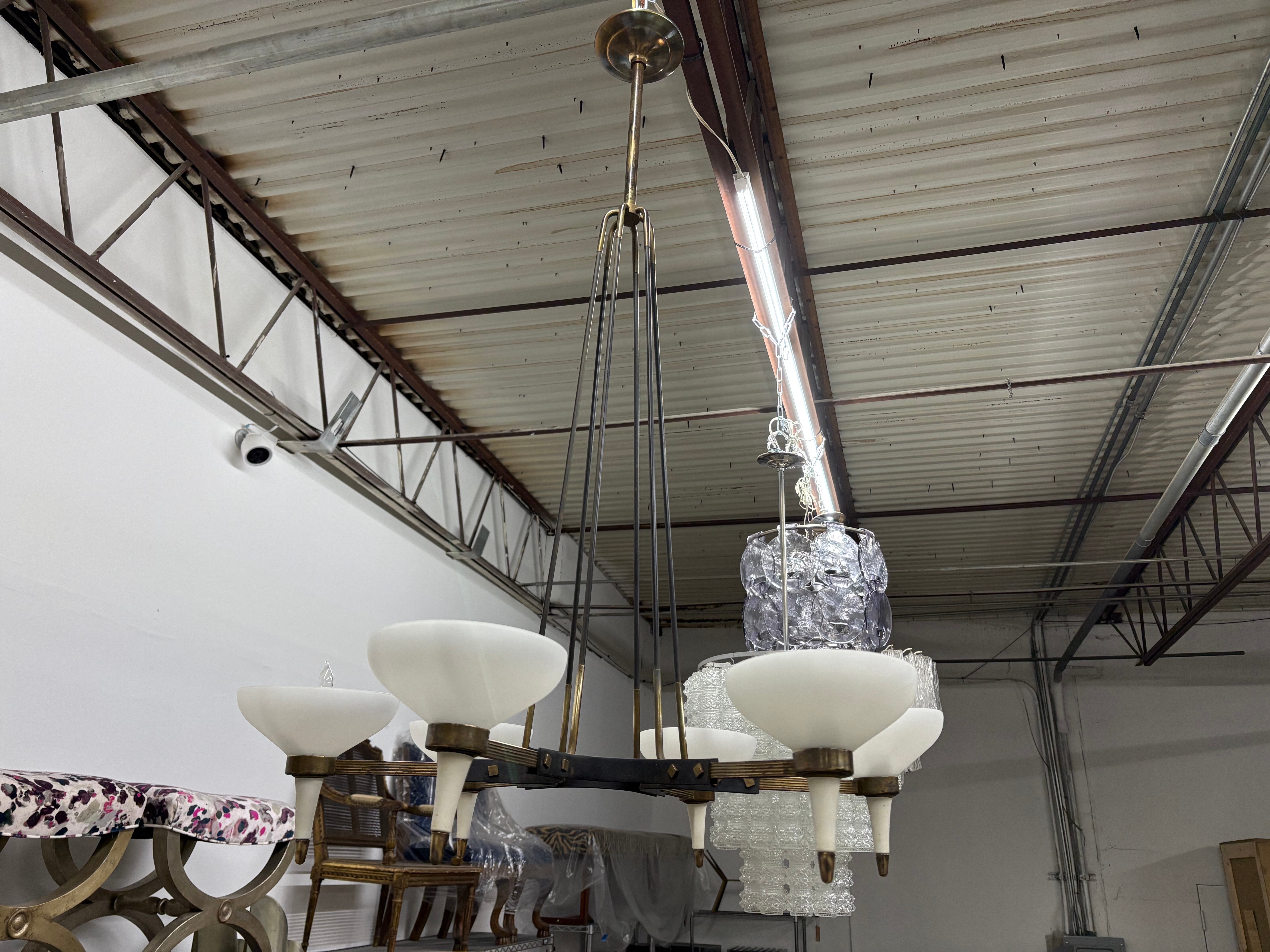 Lampadario moderno italiano di Stilnovo.
In offerta c'è uno splendido lampadario italiano di metà secolo moderno a sei bracci in ferro e bronzo con paralumi in vetro opalino.  Questo bellissimo lampadario è stato cablato di recente per il mercato