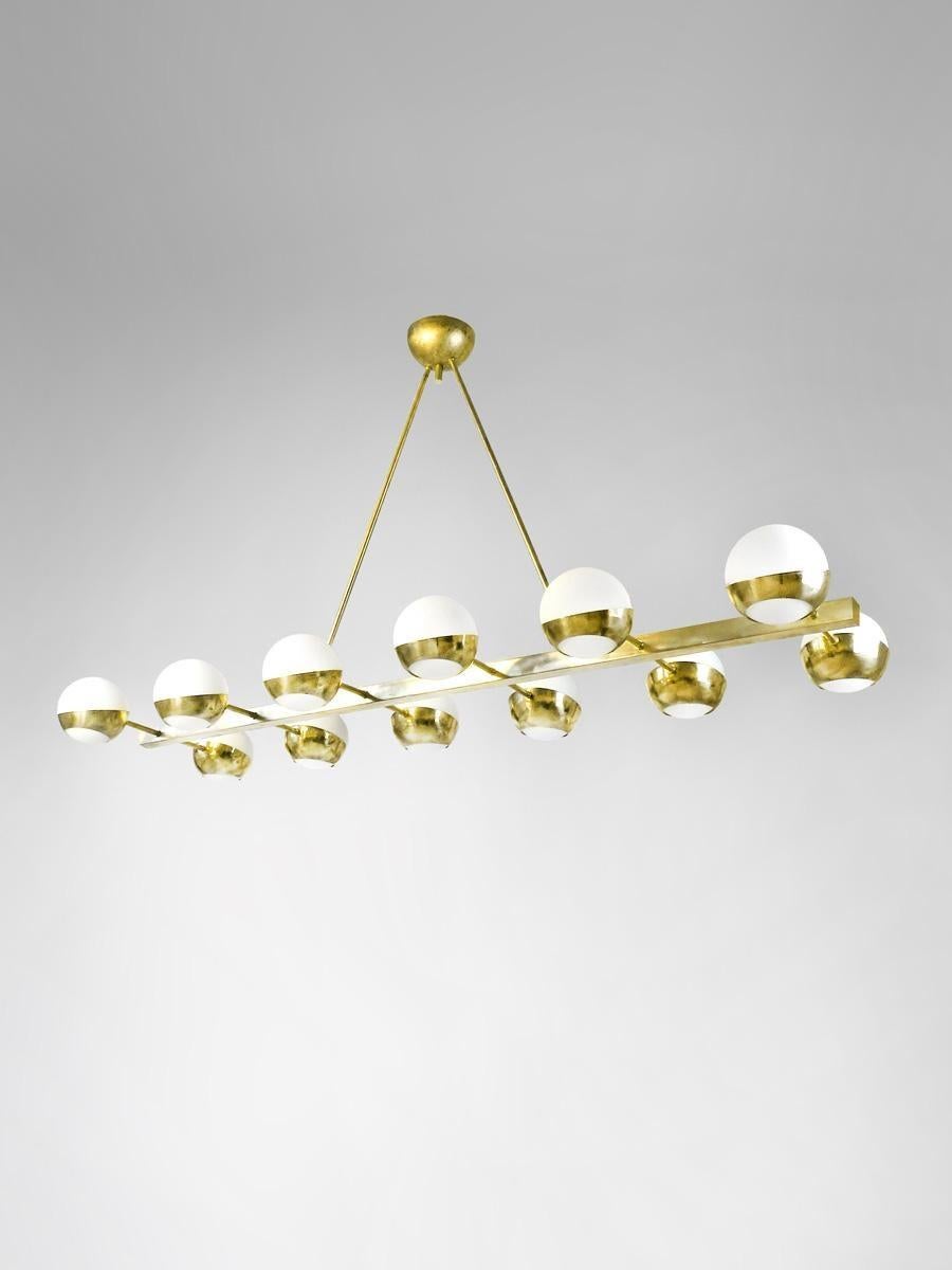 Araña escultórica clásica de latón natural sin lacar con globos de cristal opalino lechoso fabricada en Italia por Fabio Ltd. 

Con su diseño moderno y lineal, esta impresionante lámpara se integra a la perfección en cualquier ambiente. Fabricado en