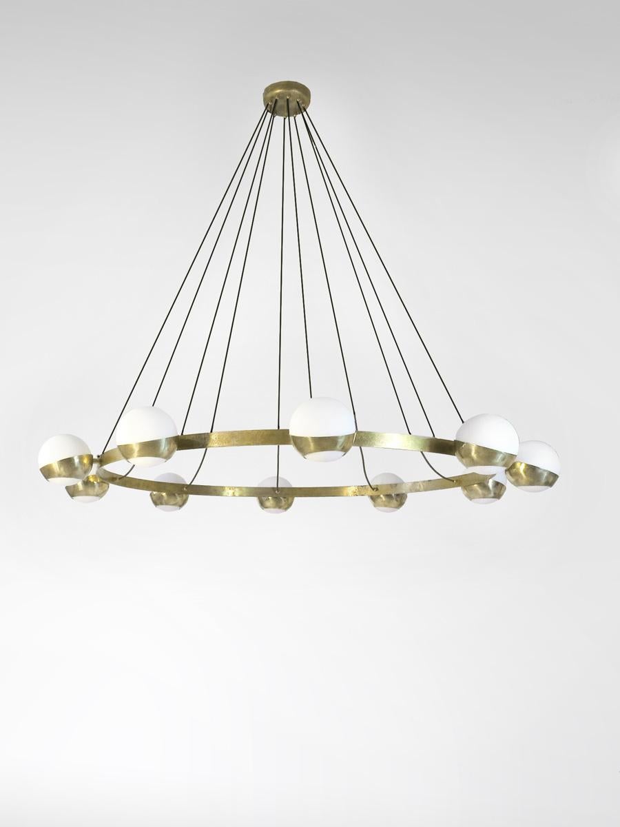 Elegant sculptural chandelier shown in un-lacquered natural brass with opaline milky glass globes fabricated in Italy by Fabio Ltd. 

This is a modern, contemporary interpretation of a classic chandelier, strongly influenced by Italian Mid-Century