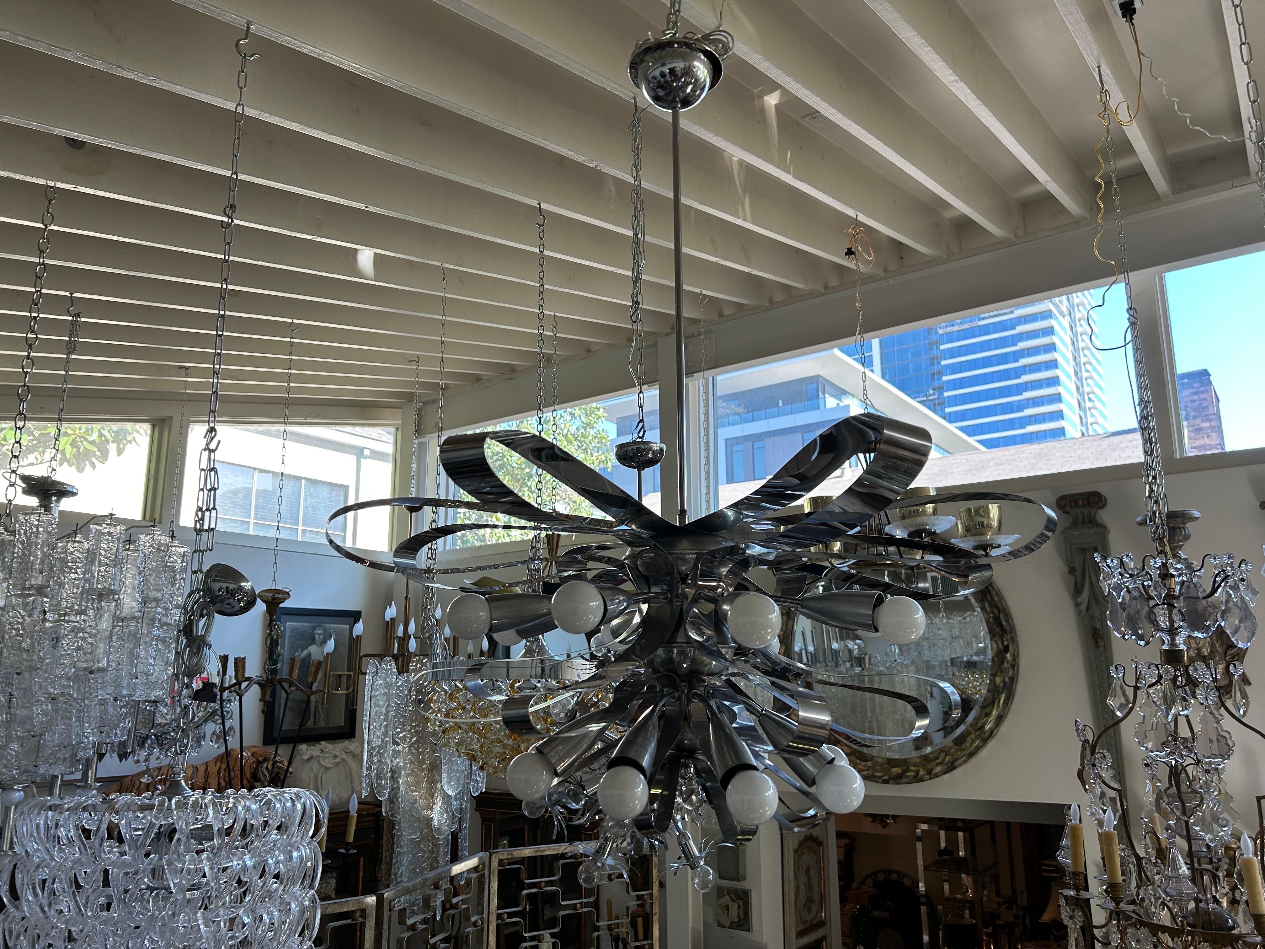 Lampadario moderno italiano in cromo di Gaetano Sciolari.
Viene offerto un  eccezionale lampadario italiano di metà secolo moderno con grandi nastri di cromo e prese multiple a candelabro che sono state cablate di recente con nuove prese per il