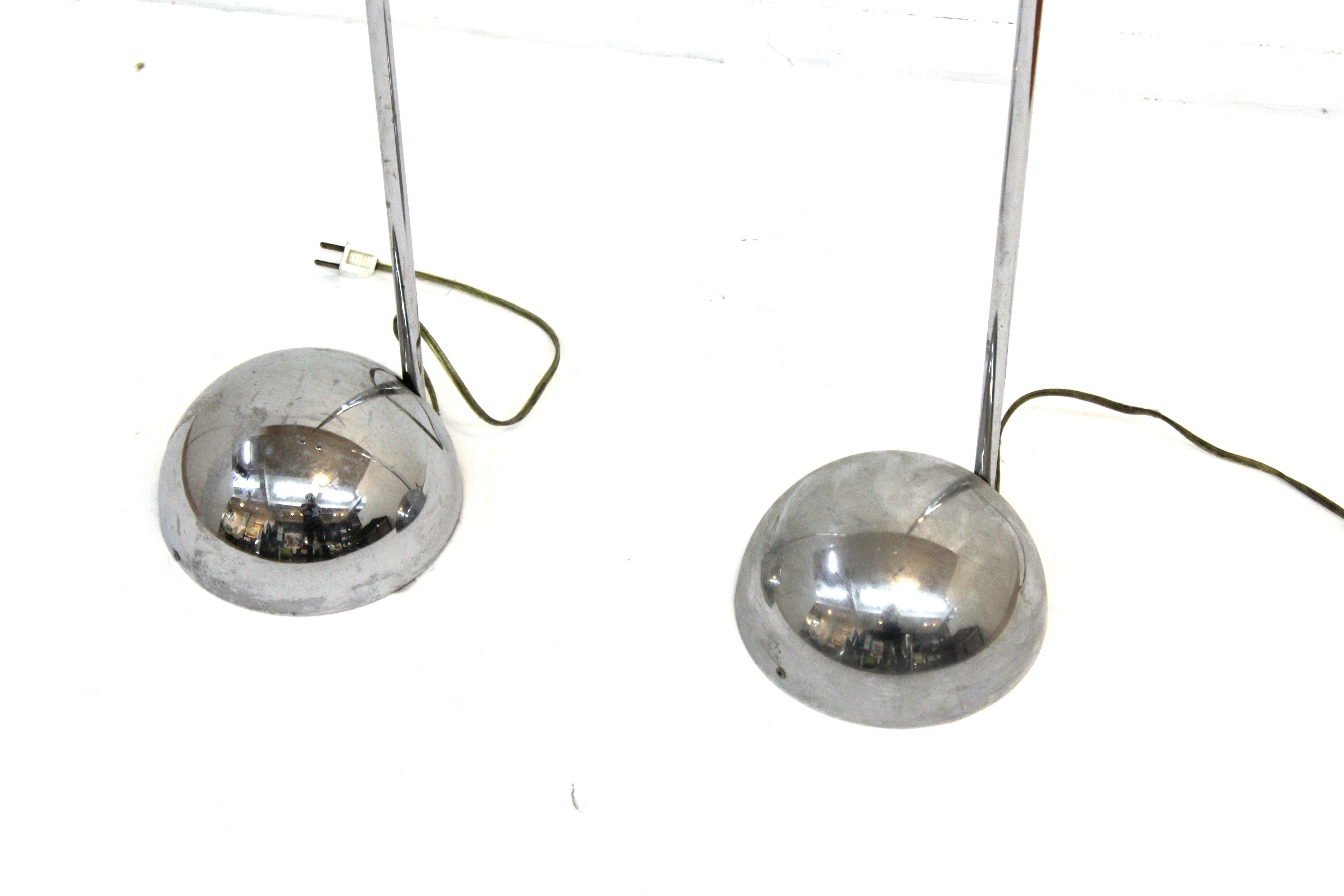 Italian Modern pair of torchiere floor lamps in chromed metal. The pair was likely made in Italy during the 1960s-1970s. IN great vintage condition with age-appropriate wear and use.