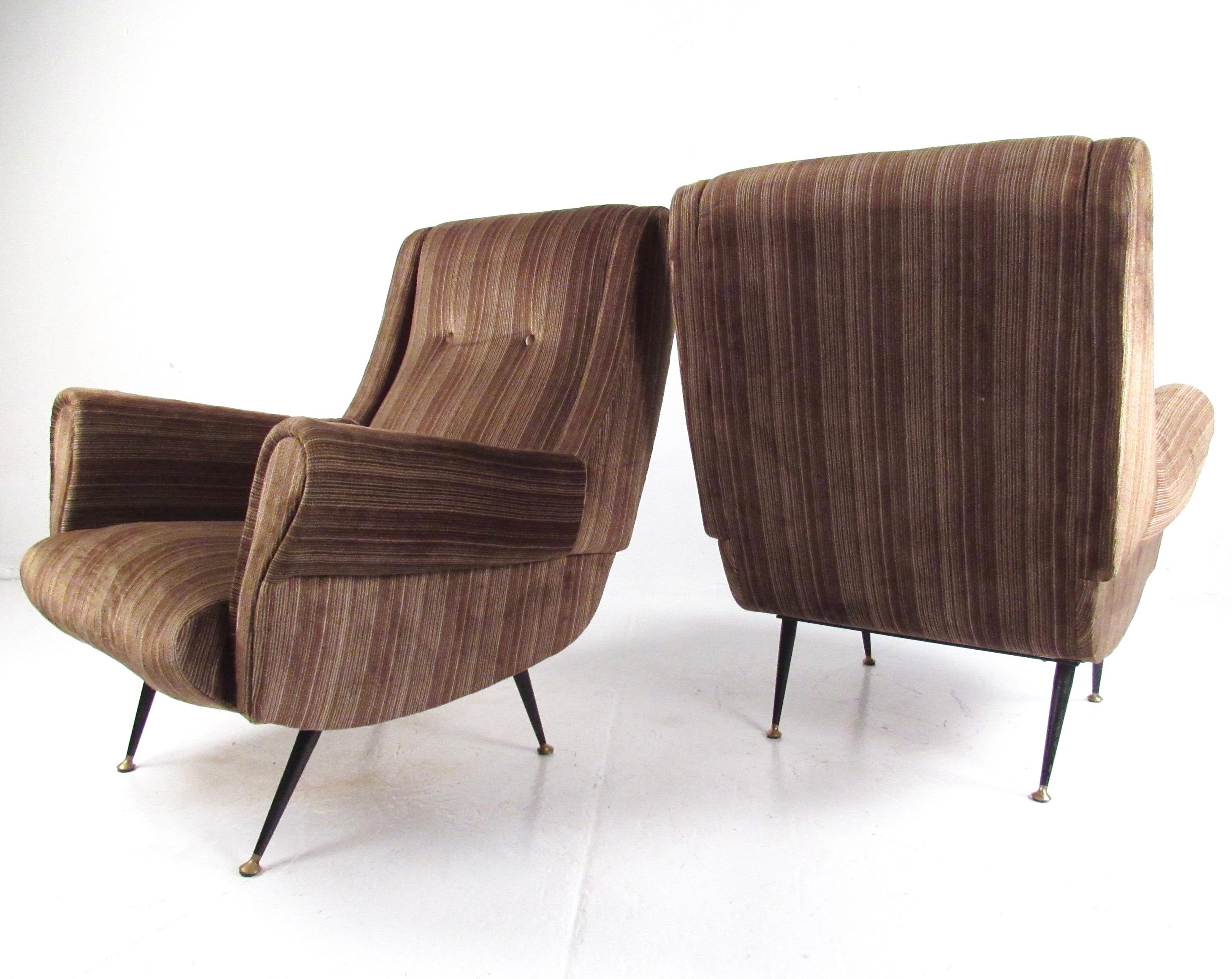 This striking pair of 1950s Italian modern lounge chairs feature sturdy mid-century construction and unique tapered metal legs. The shapely sculptural design in the style of Gigi Radice is complimented by the vintage upholstery. Please confirm item