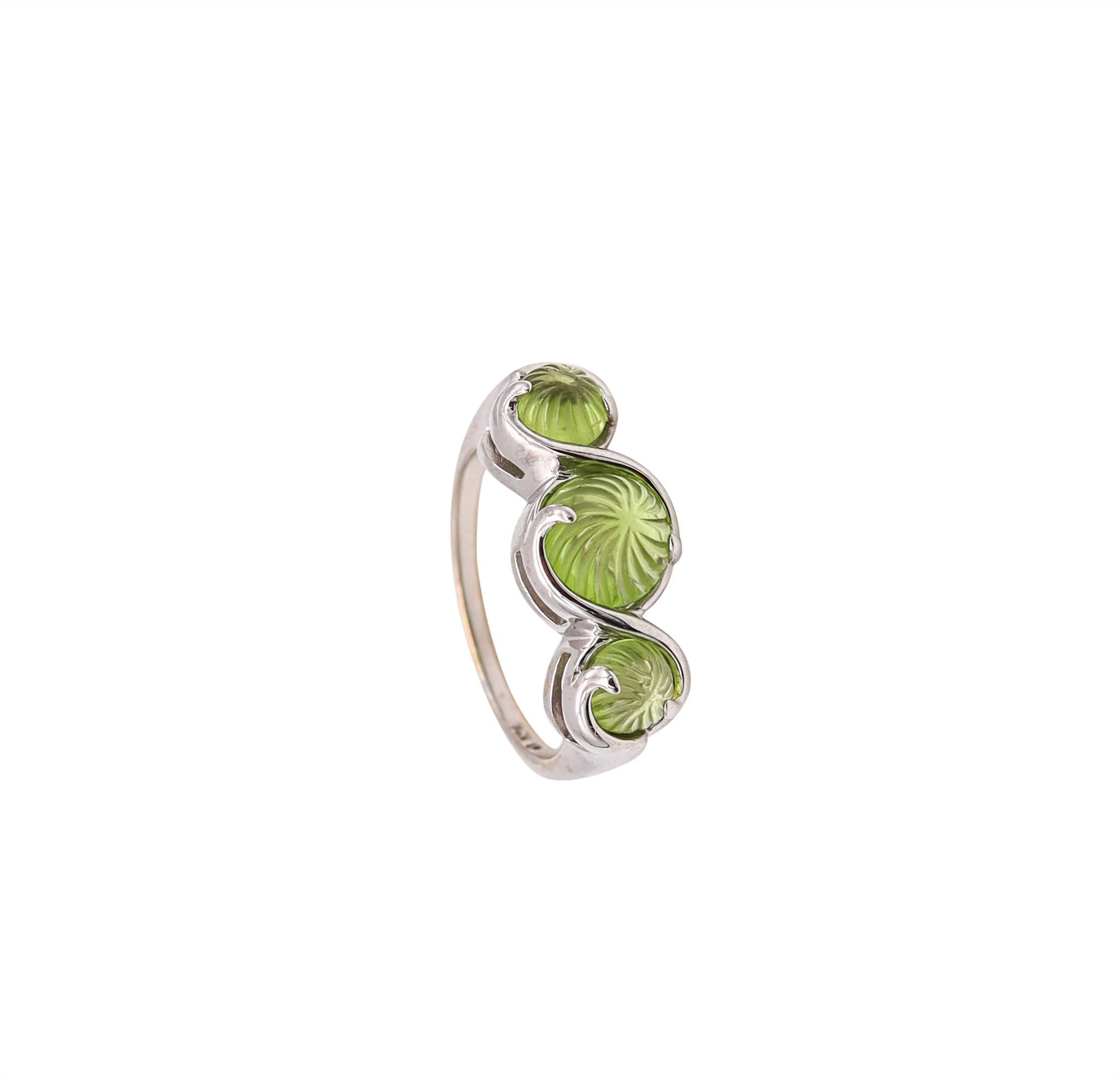 Modern ring with fluted Peridot.

A colorful piece, crafted in Italy in solid white gold of 14 karats white gold, with high polished finish. Mounted on top in three bezels, with fluted round cabochon cut of natural vivid green peridots, with an