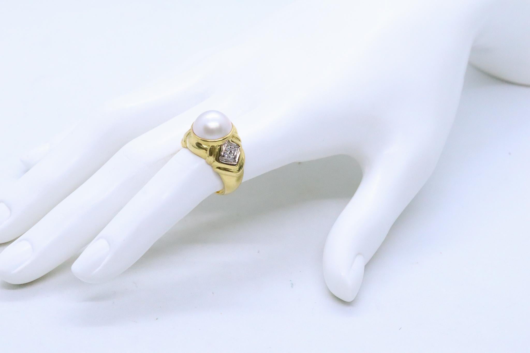 Cocktail ring with a white pearl of 11mm.

Modern classic piece, crafted in Italy in solid yellow gold of 18 karat and finished with high polish. Us mount in the center in a bezel setting, with a white Mobe pearl of 11 mm.

Accented at the sides,