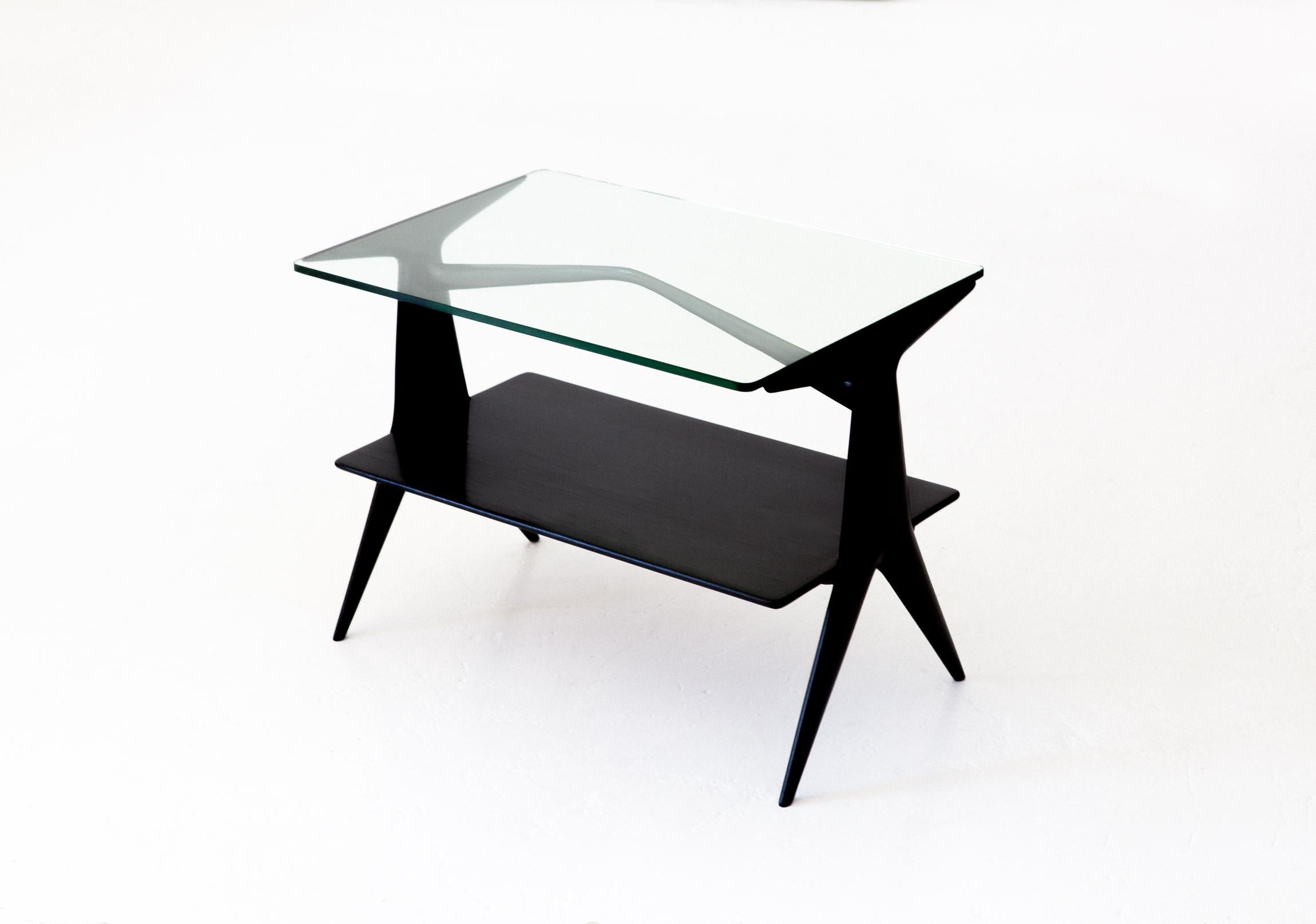 A sculptural and airy low table manufactured in Italy in 1950s
Solid mahogany wood with glass top. Completely restored, hand polished with natural shellac, aniline black stained .This kind of restoration has required a week of work.
Its shape is