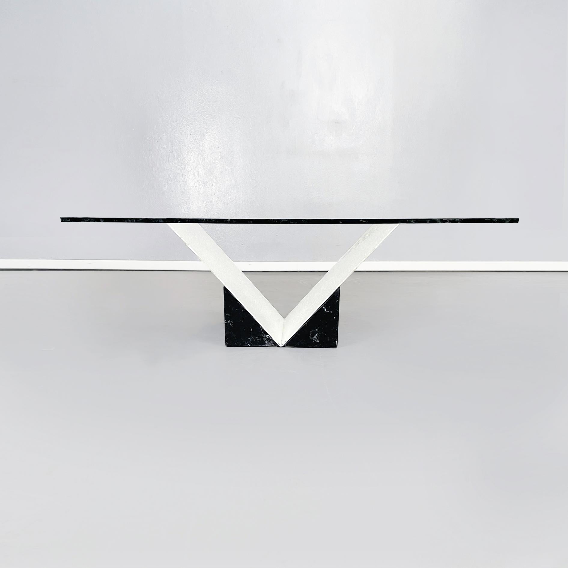 Italian modern Coffee table in glass, white metal, black marquinia marble, 1980s.
Coffee table with square thick glass top. The base is made up of a V-shaped structure in white painted metal, set in a block of black marquinia