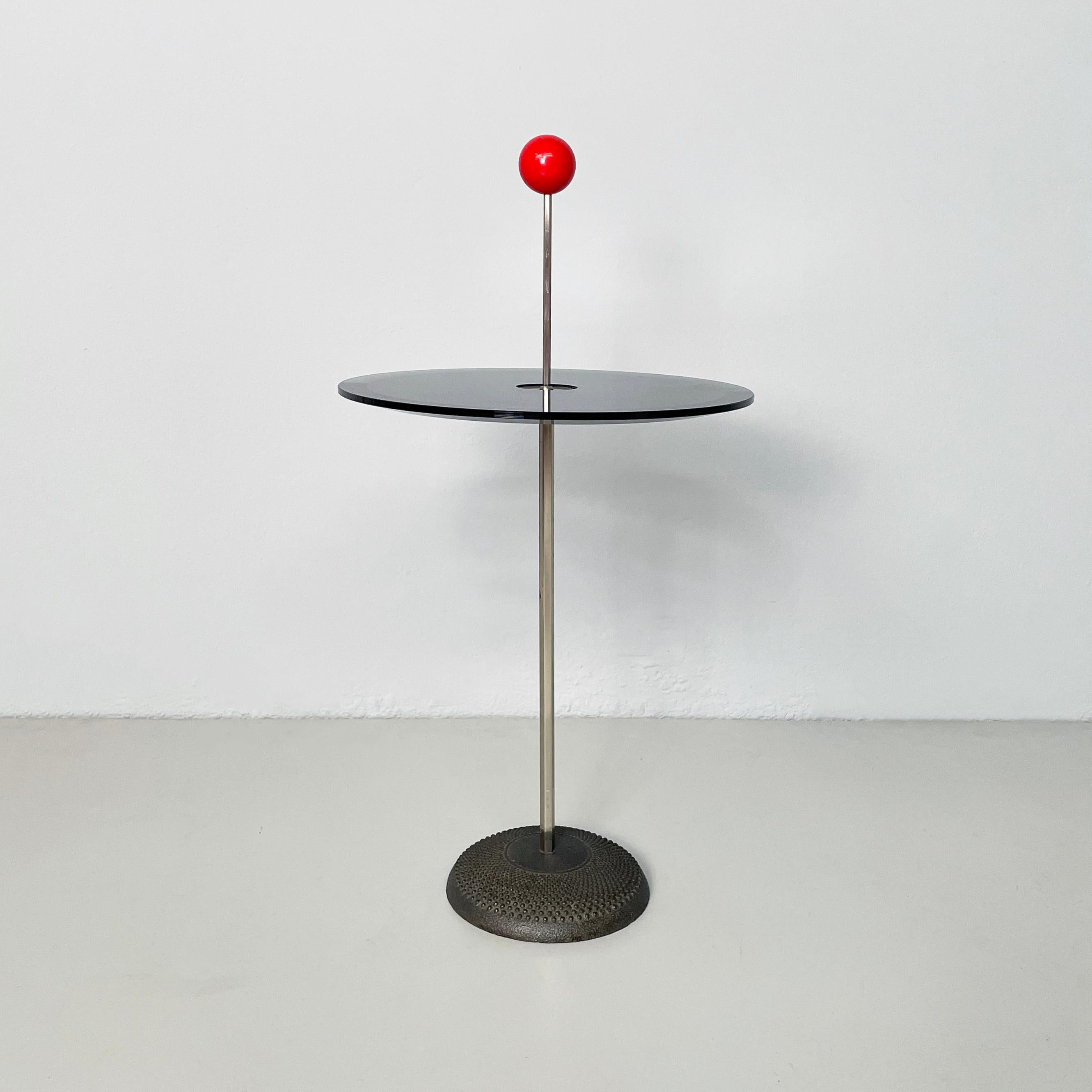 Italian modern Coffee table Orio by Pierluigi Cerri for Fontana Arte, 1980s
Coffee table mod. Orio with round top in smoked glass with bevelled edge. The metal structure features a spherical red resin handle. The round base is made of worked cast