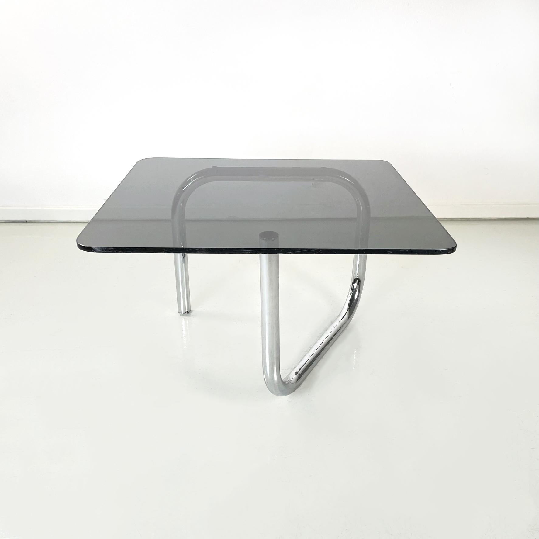 Table basse moderne italienne en verre fumé rectangulaire et acier chromé, années 1970.
Table basse avec plateau rectangulaire et coins arrondis en verre fumé. La structure est constituée d'un seul tube d'acier chromé à la forme sinueuse.
Cette
