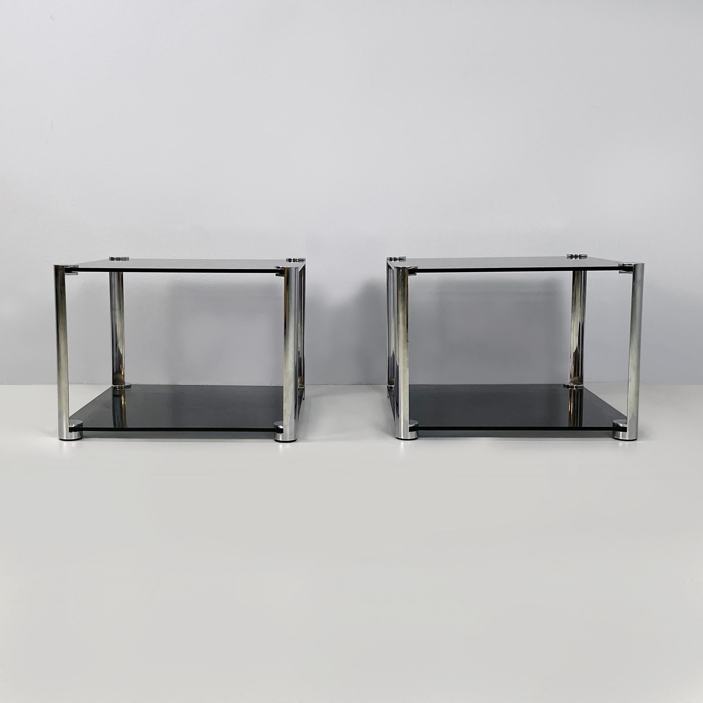 Tables basses italiennes modernes en verre fumé et métal chromé, années 1980
Paire de tables basses à double plateau quadrillé en verre fumé. La structure d'une table est constituée de 4 cylindres en métal chromé, dans lesquels s'insère le plateau.
