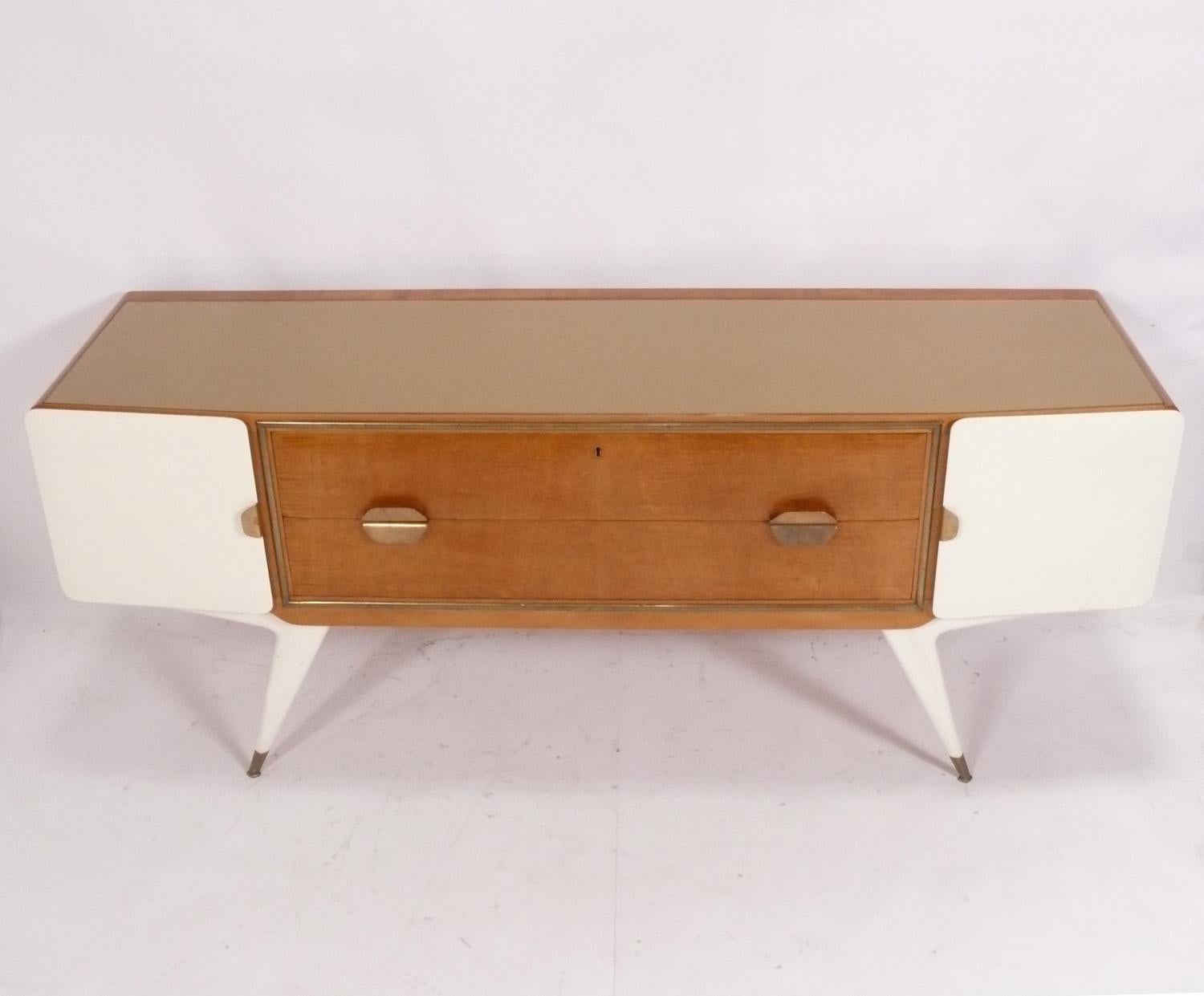 Elegante italienische Kredenz aus weiß lackiertem und natürlichem Holz mit Messingbeschlägen, im Stil von Gio Ponti, unsigniert, Italien, um 1950er Jahre. Es bietet viel Stauraum mit zwei tiefen, breiten Schubladen in der Mitte, flankiert von zwei