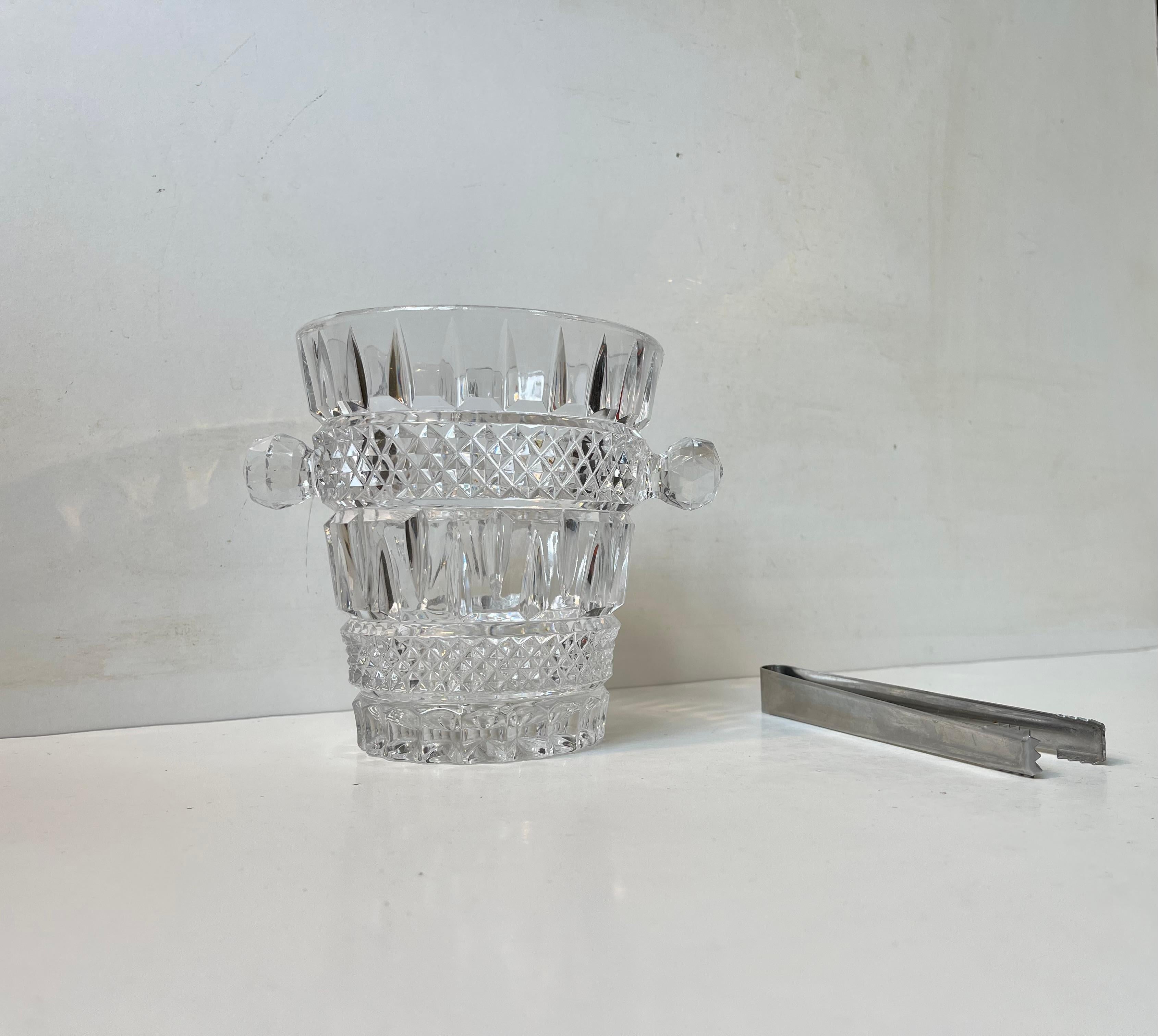 Un seau à glace élégant présentant de multiples faits, des motifs en forme de diamant et des poignées décoratives. Le seau à glace a été fabriqué en Italie vers 1960-70. Il est livré avec une pince à glace d'époque en acier inoxydable. Dimensions :