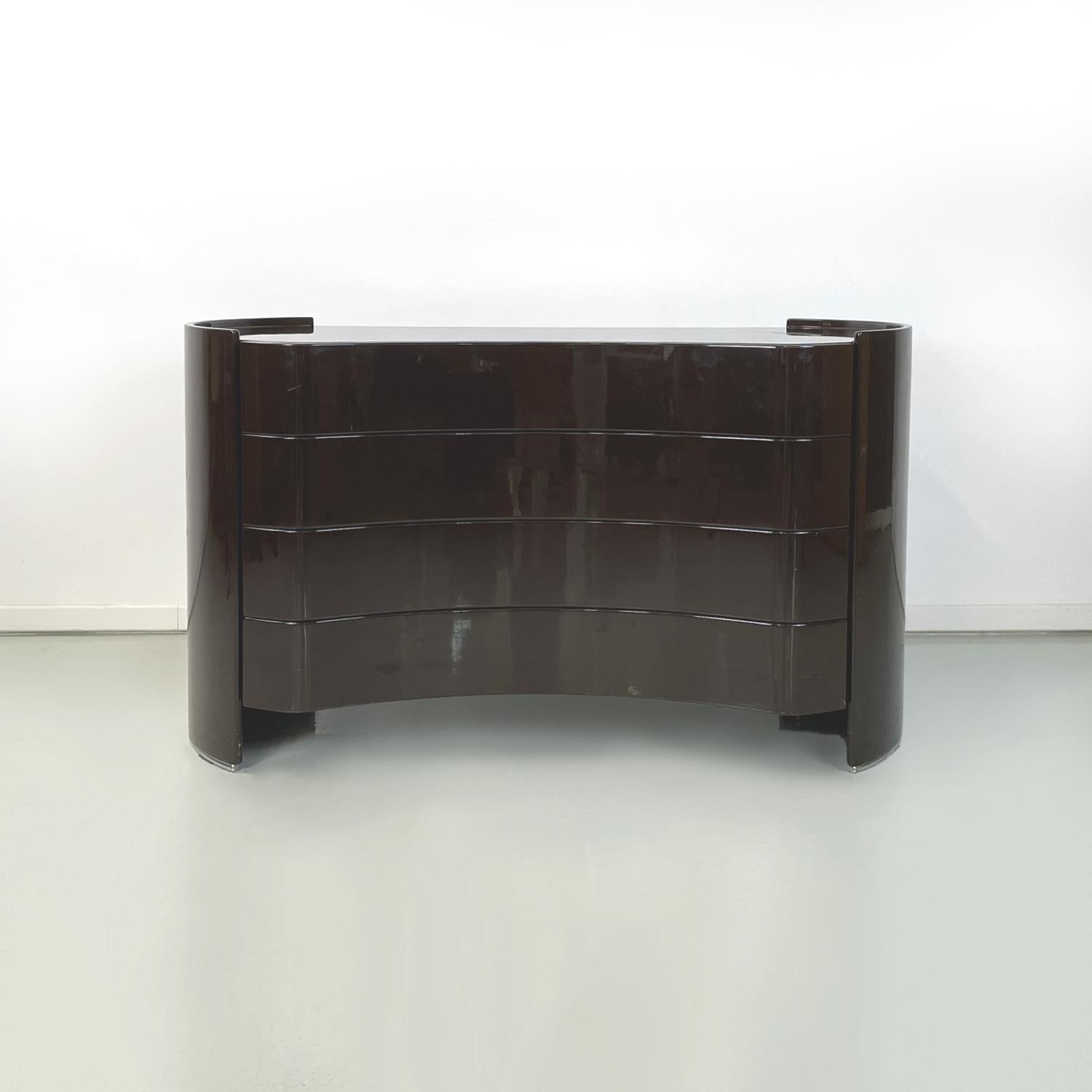 Italian modern Dark brown lacquered wooden chest of drawers Aiace by Benatti, 1970s
Chest of drawers with a rounded and sinuous shape, entirely in dark brown lacquered wood. On the front it has 4 drawers. On the sides it has two metal rod