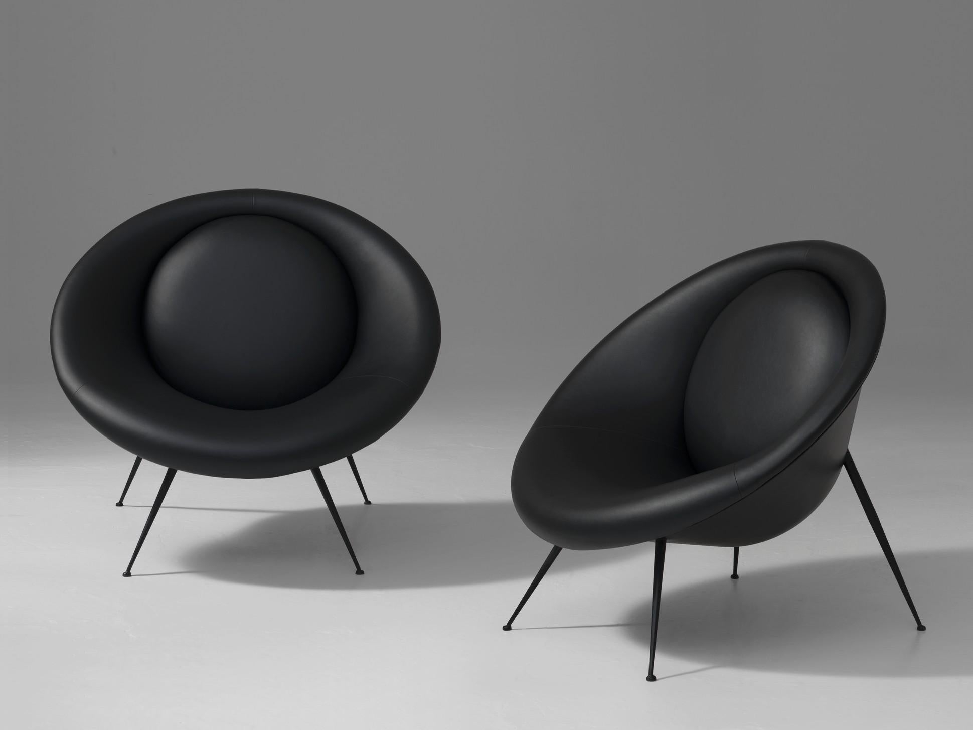 Outstanding shape, cocooning, organic and Italian handcraft lounge armchair compose of a fiberglass shell wearing a comfy black leather with black metal feet.