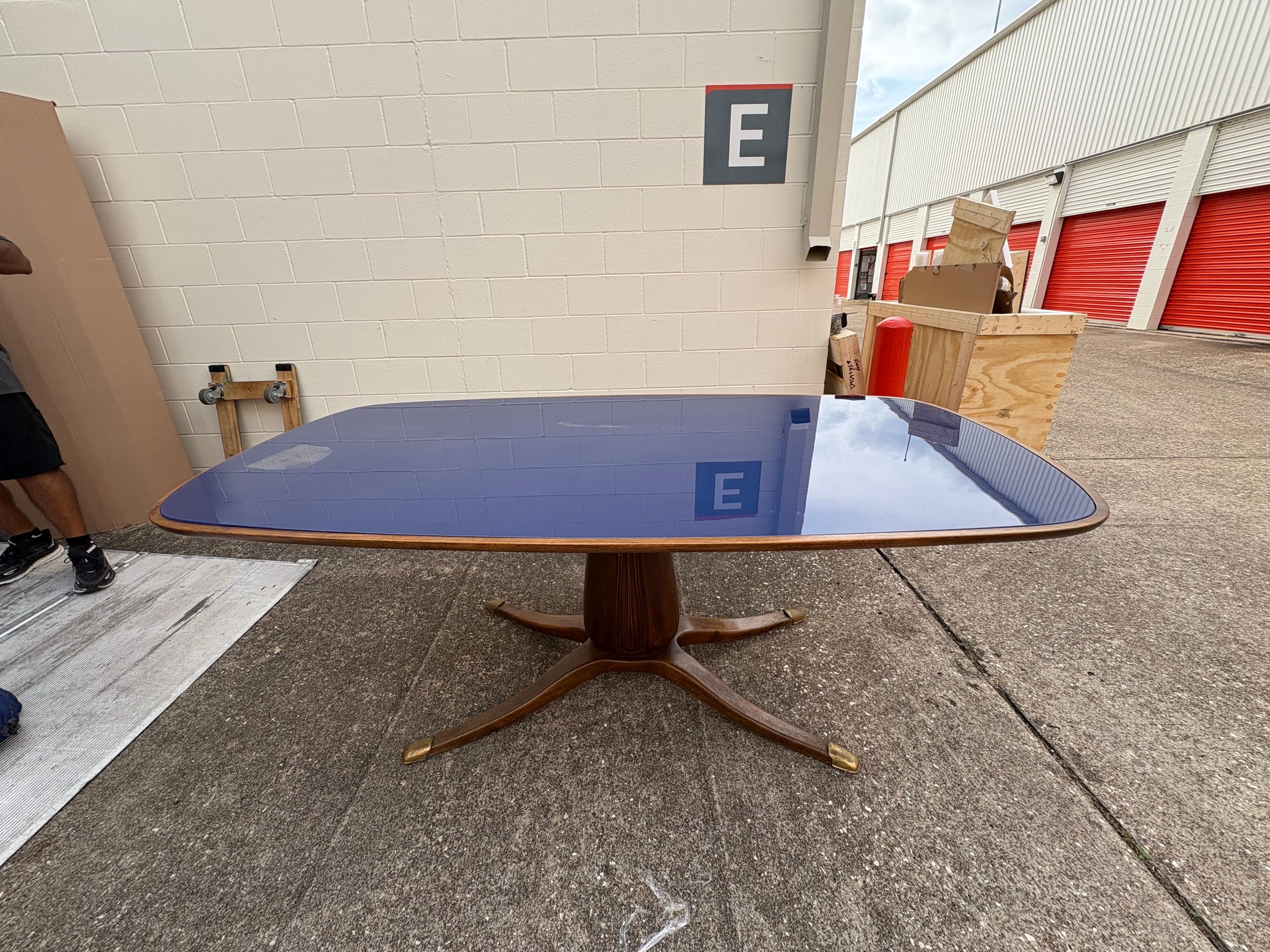 Tavolo da pranzo moderno italiano di Vittorio Dassi.
Si tratta di un bellissimo tavolo da pranzo rettangolare scultoreo con base a piedistallo, piano in vetro blu cobalto e gambe strombate con sabot in bronzo.
Questo tavolo da pranzo italiano di
