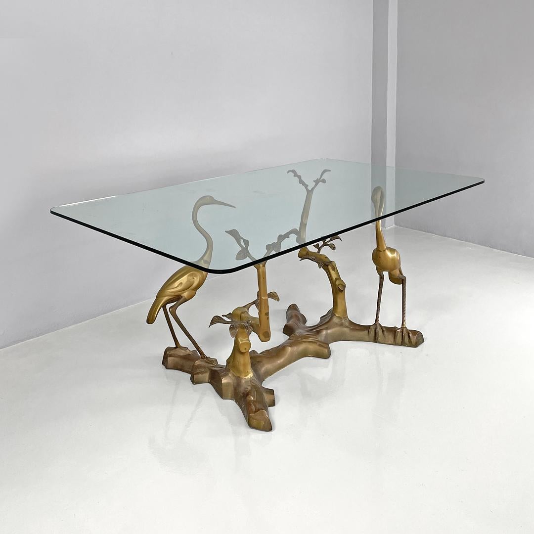 Italian modern dining table with sculpted and decorated brass structure, 1970s
Dining table with rectangular glass top. The top rests on the main structure which is entirely made of brass and is richly decorated, the four legs are two in the shape