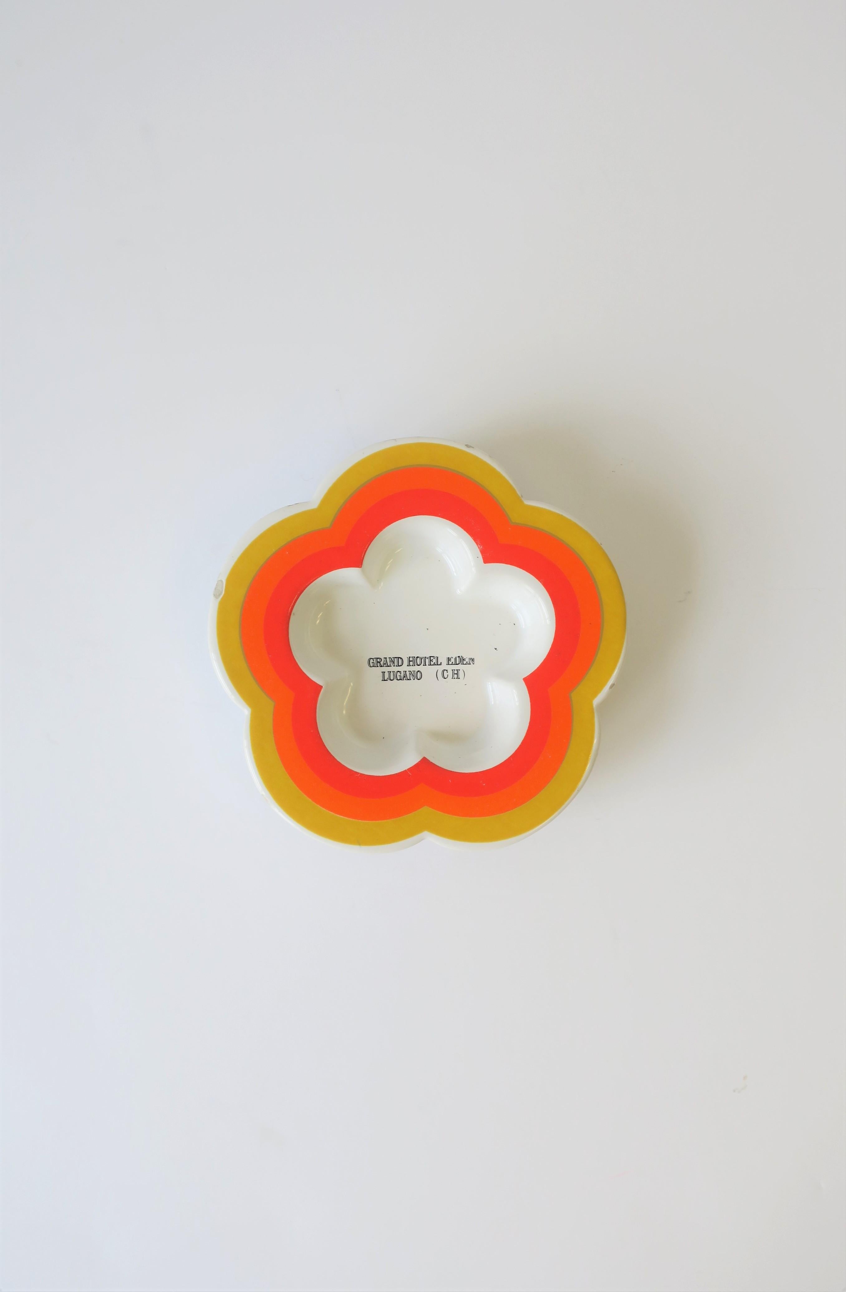 A chic '70s Italian Modern or Postmodern period ceramic dish or vide-poche (catch-all) for small items such a jewelry as demonstrated, circa 1970s, Italy. Dish has a modern 'flower' shape design in white ceramic with rainbow colors of yellow, orange