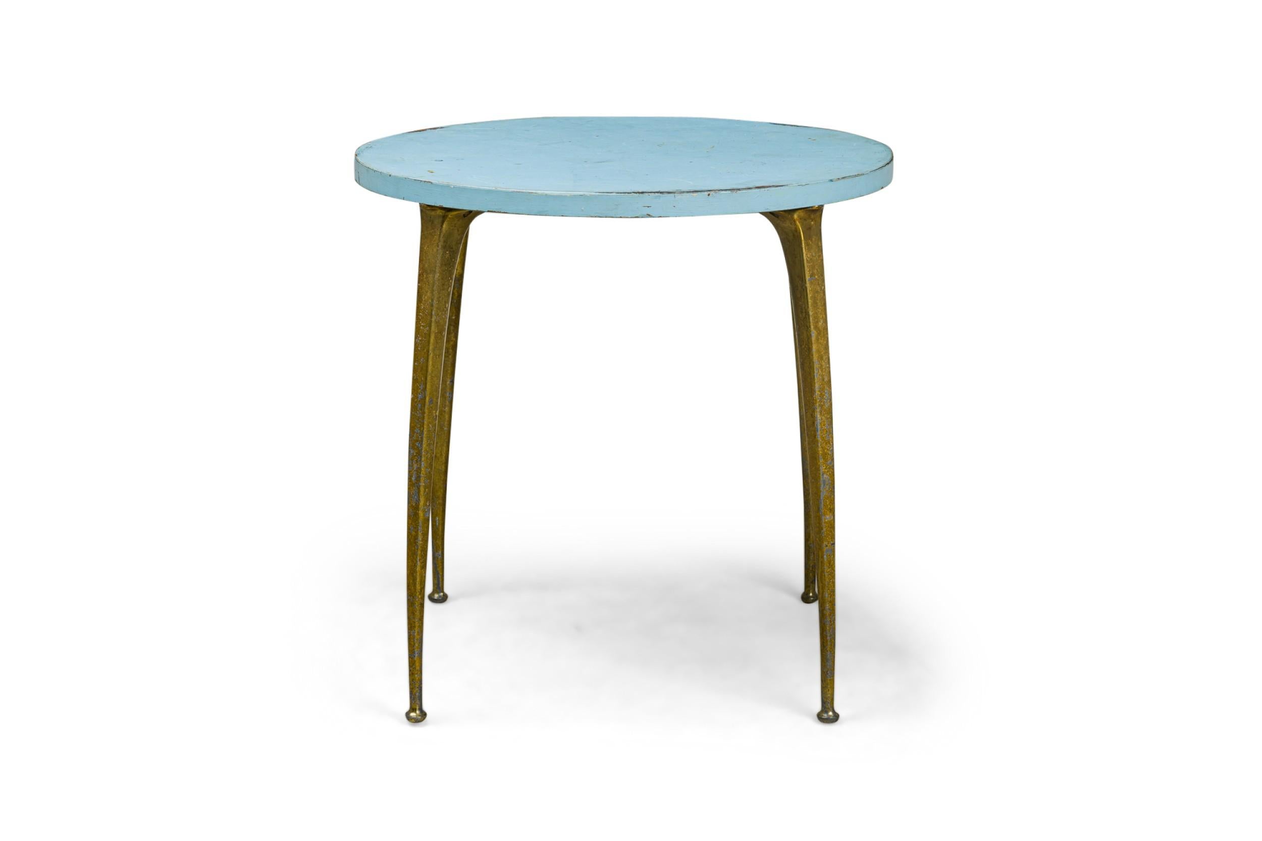 Italian Mid-Century Modern center / breakfast table with a sky blue enameled circular wood top, resting on four sculptural brass legs tapering toward the bottom. (in the style of GIO PONTI)
 

 Wear to finish.
