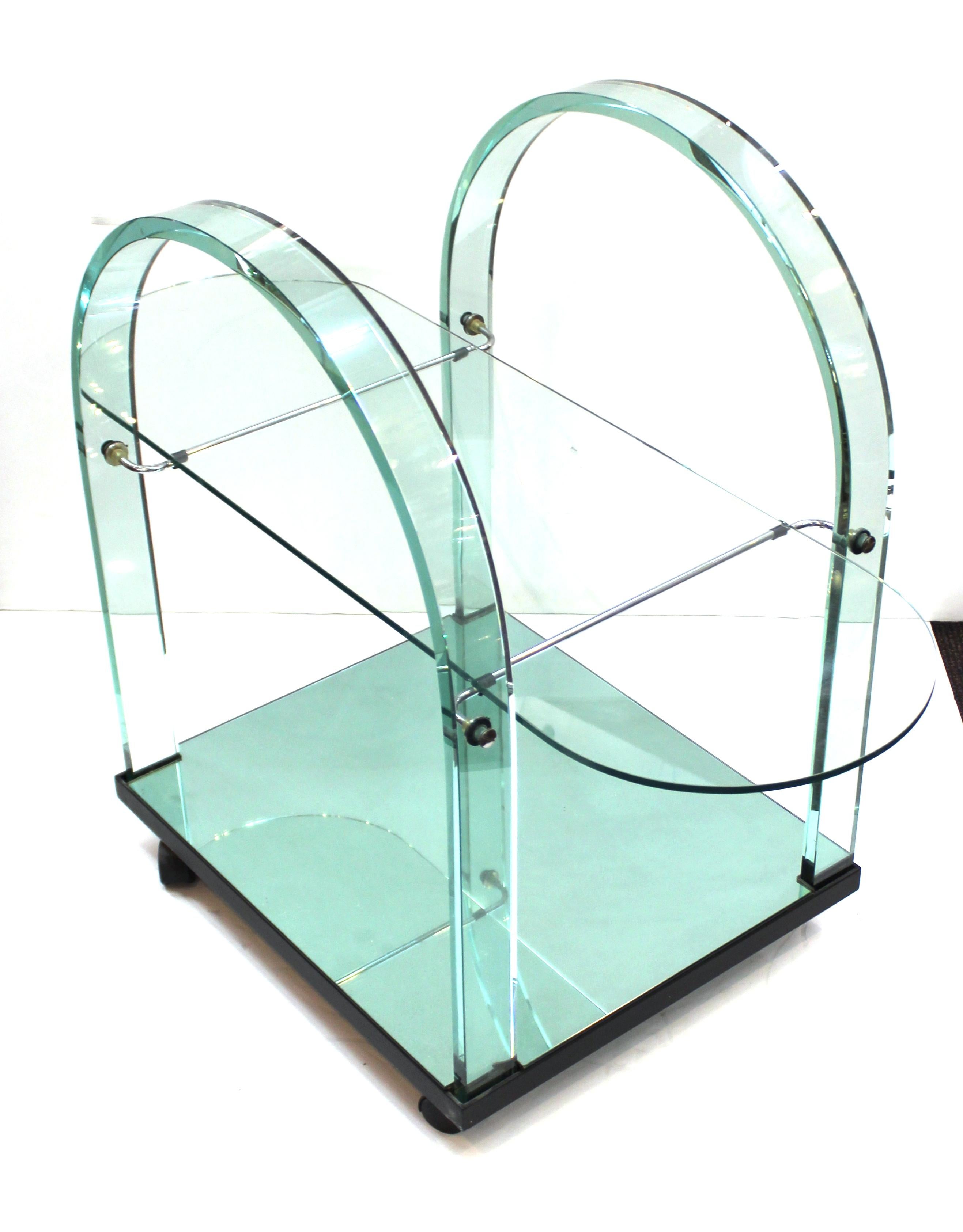 Italian modern bar or tea cart designed by FIAM in the circa 1970s. The piece has a mirrored bottom and a heavy curved glass handle structure, which is a specialty of FIAM, a renown Italian glass producer. Makers mark on the base of the leg. In
