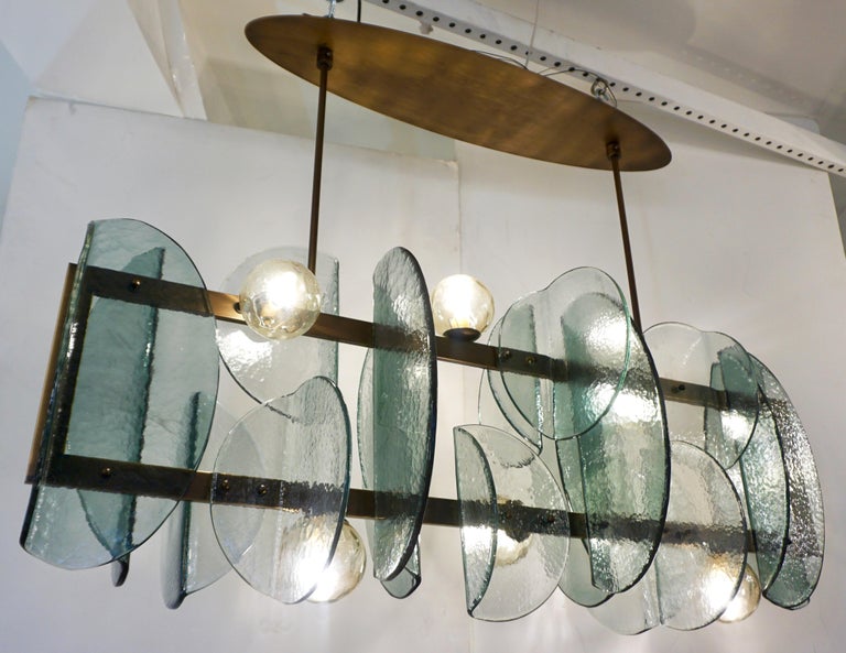 A contemporary creation with a unique modern geometric design, this exclusive chandelier is entirely handcrafted in Italy. The molded textured murano glass elements have an expressive organic rounded shape, in a special green blue aquamarine color