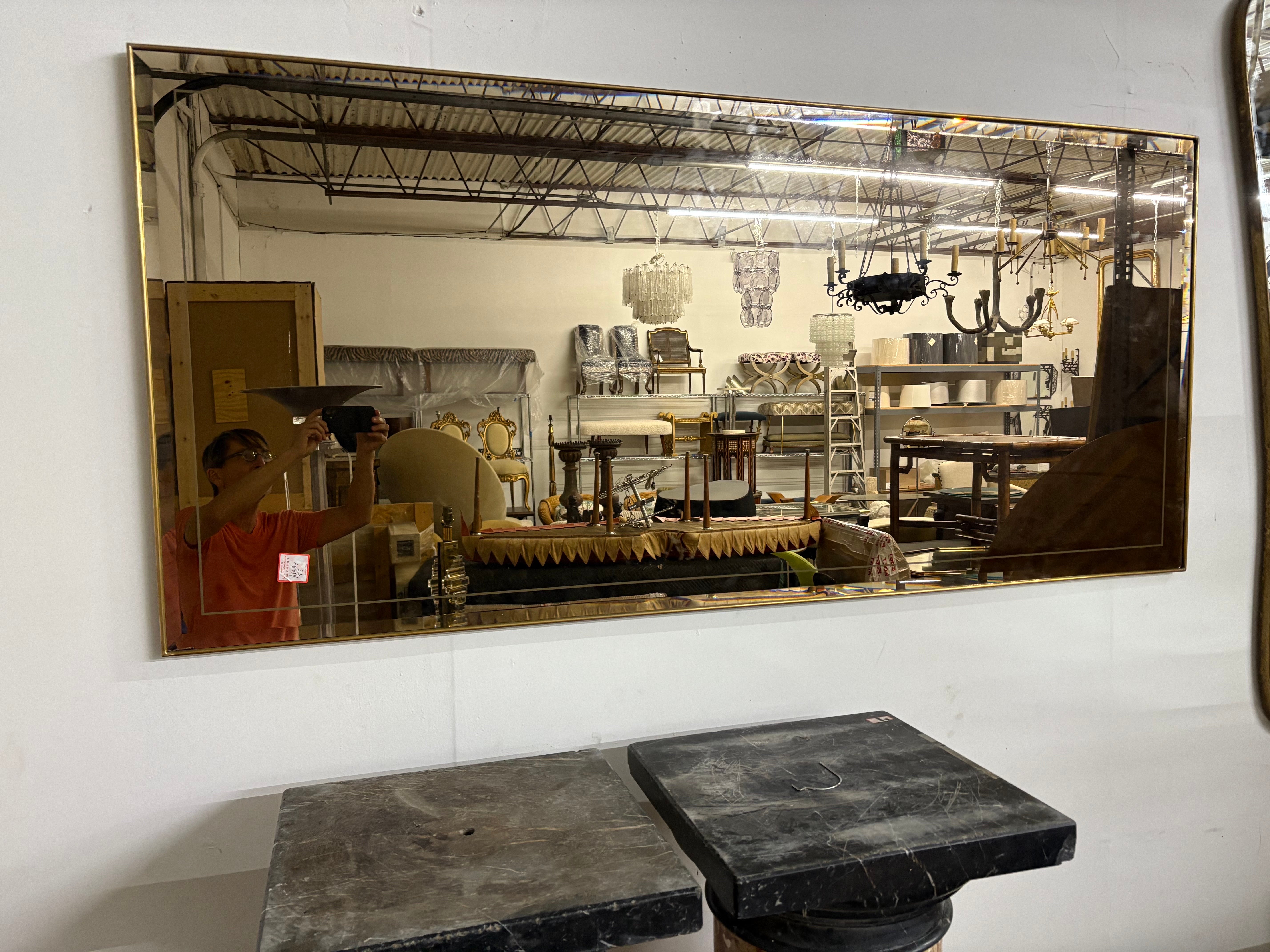 Specchio smussato in stile Fontana Arte moderna italiana.
In offerta c'è un delizioso specchio di grandi dimensioni in ottone incorniciato e smussato in bronzo. Questo specchio insolito può essere esposto sia in orizzontale che in verticale.
La