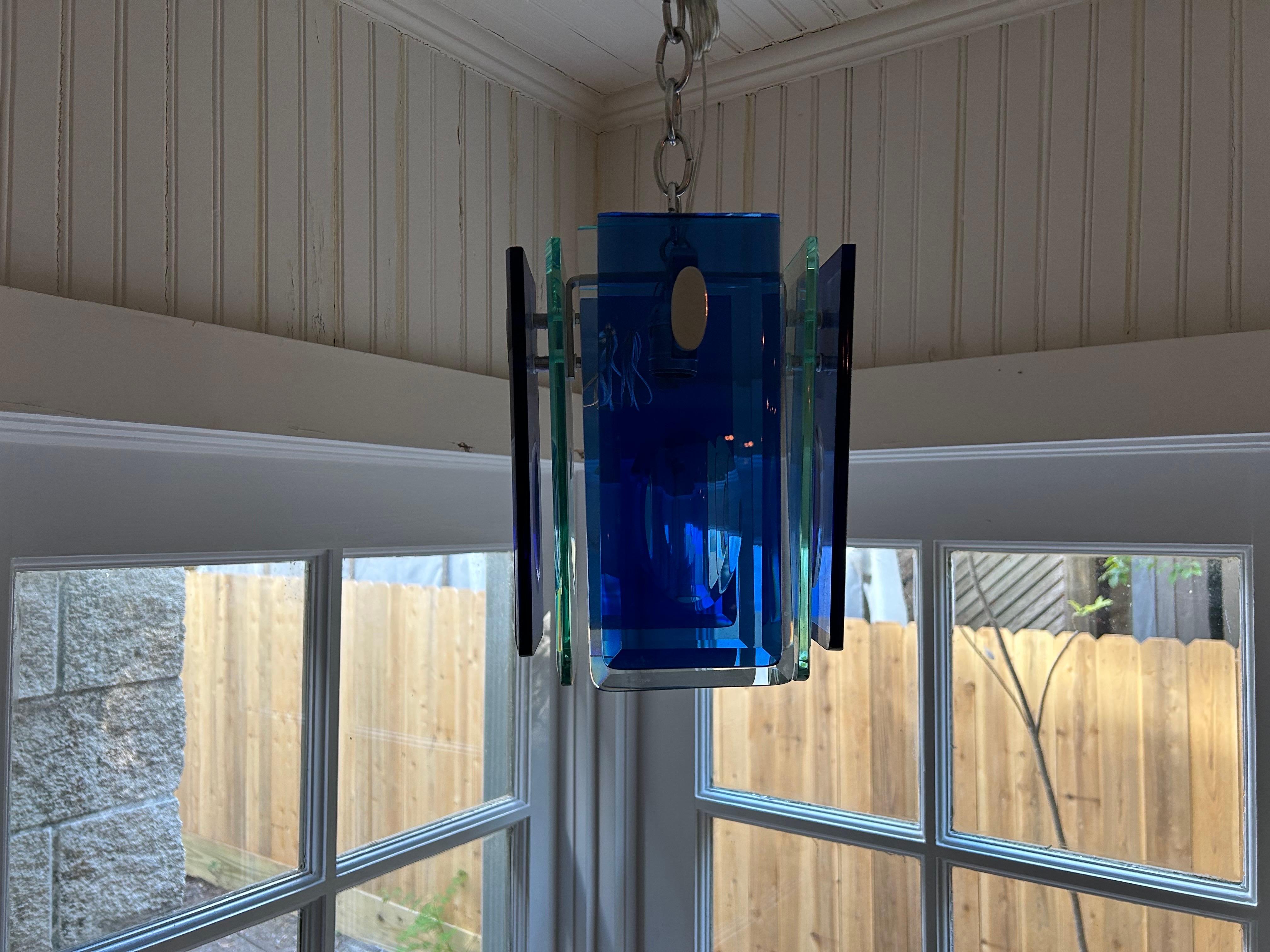Italian Modern Fontana Arte Style Pendant Or Lantern.
Beautifully executed Italian mid century modern pendant or lantern with alternating sheets of blue and transparent glass on a chrome structure.
Our pendant has been newly wired for the U.S.