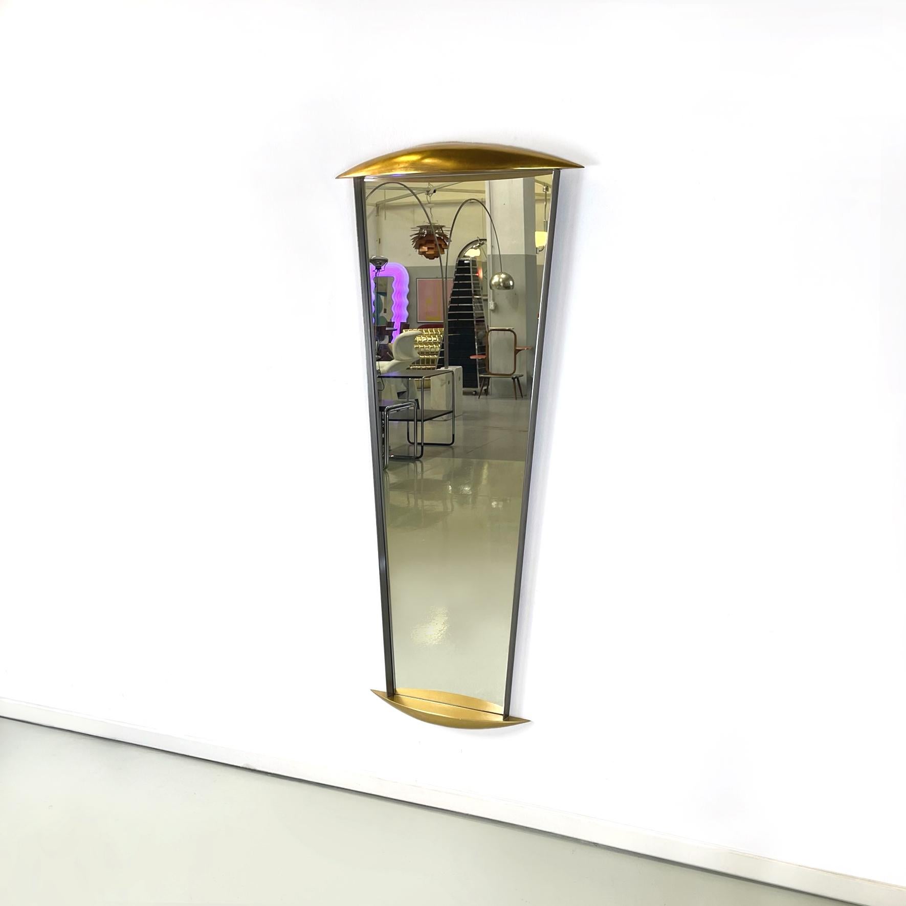 Italian modern Full-length wall mirror in gold wood and metal, 1980s
Full-length wall mirror with wooden and metal profiles. The upper and lower profile has two semi-ovals in wood with a golden finish. On the sides it has two thin metal plates.