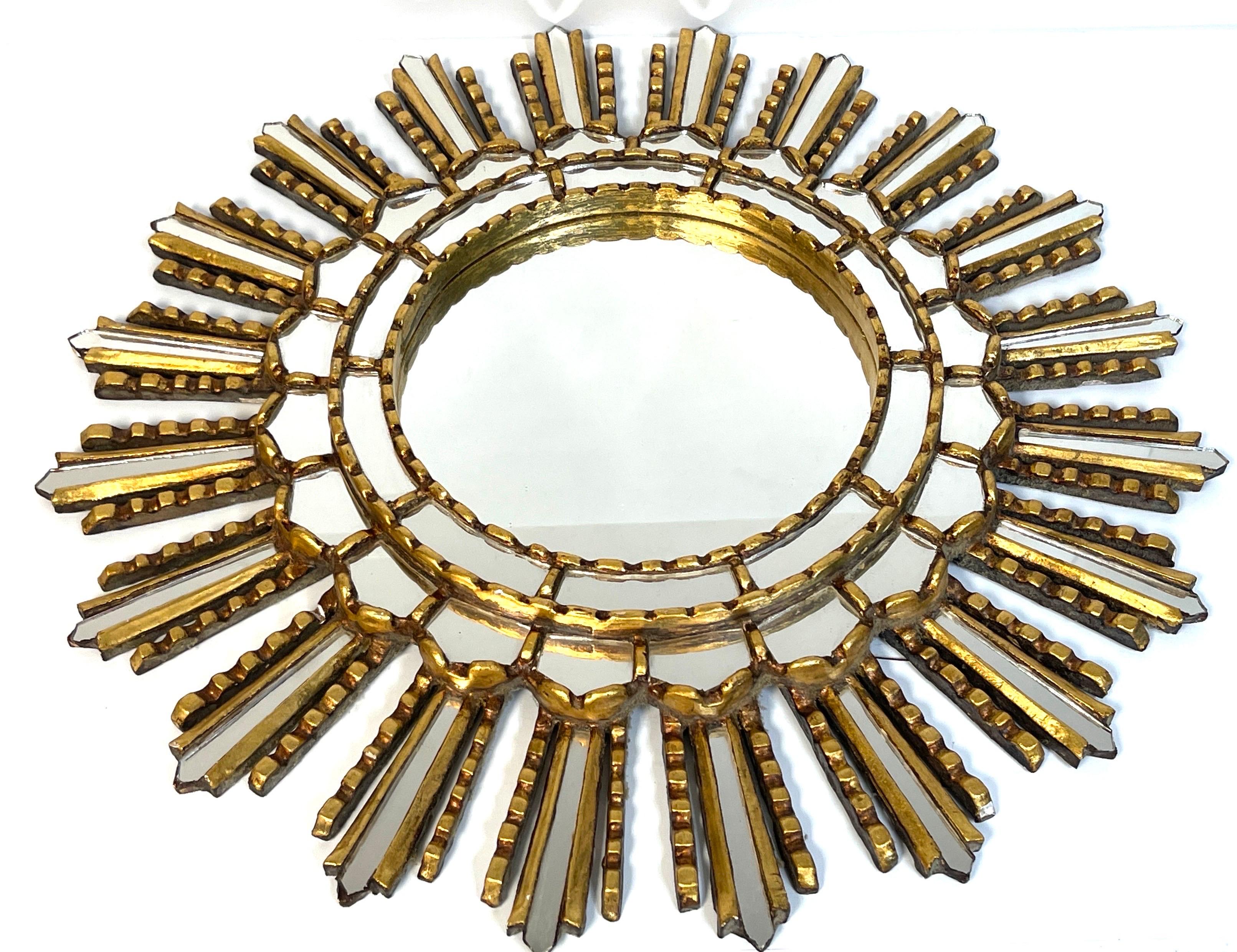 Italian modern giltwood sunburst mosaic mirror 
Italy, circa 1960s
Of good size with a 20-inch overall diameter, with inset 8-inch mirror, surrounded by a continuous two tiered giltwood inset mirror mosaics, the outer layer with
alternating rays