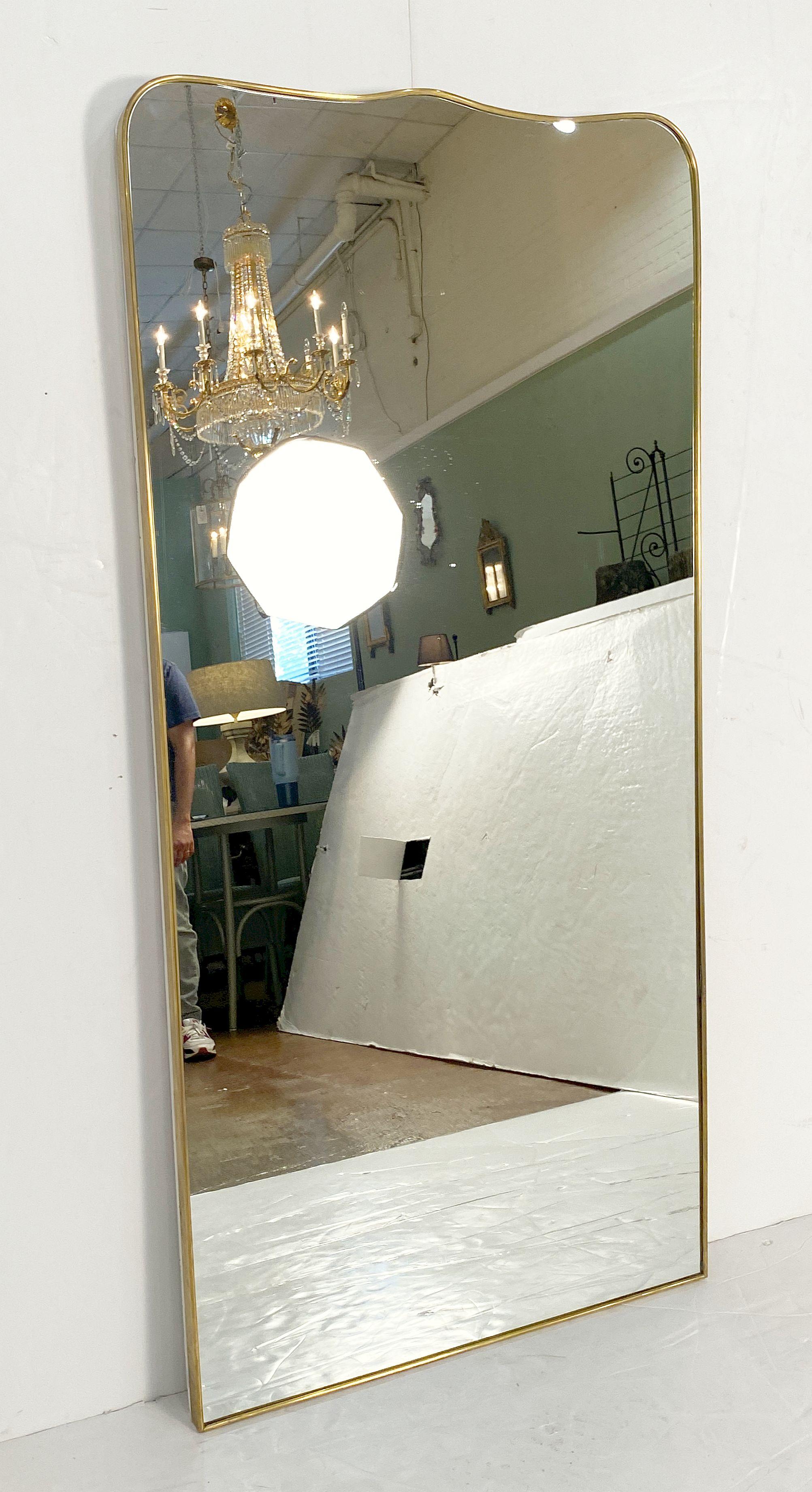A fine large Italian Modern full-length wall or dressing mirror featuring a clean, Mid-Century design with an elegant, curved frame in brass, in the style of the famed designer, Gio Ponti. (Italian, 1891-1979)

An architect, furniture and industrial