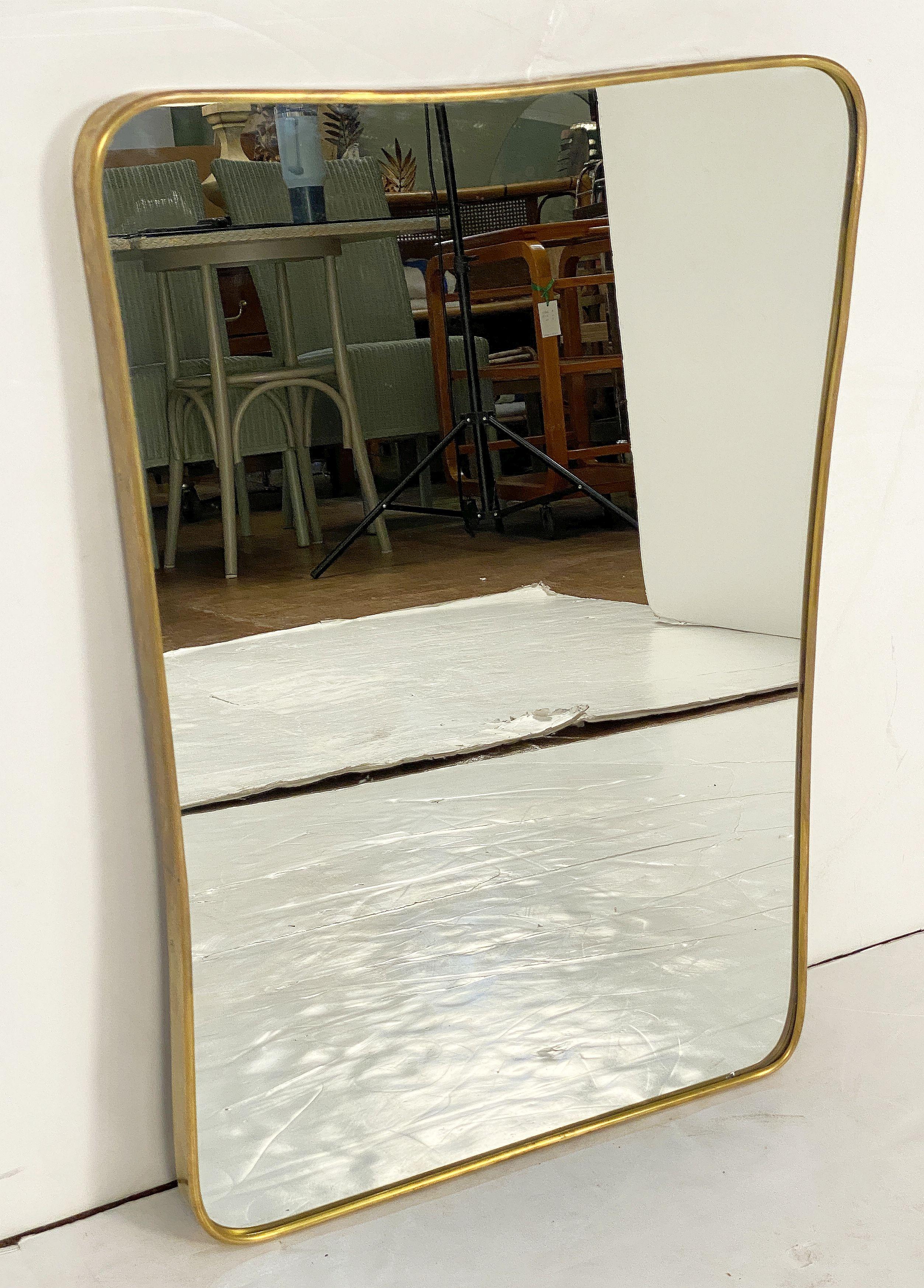 A fine Italian Modern wall mirror featuring a clean, Mid-Century design with an elegant, curved frame in brass, in the style of the famed designer, Gio Ponti. (Italian, 1891-1979)

An architect, furniture and industrial designer and editor, Gio