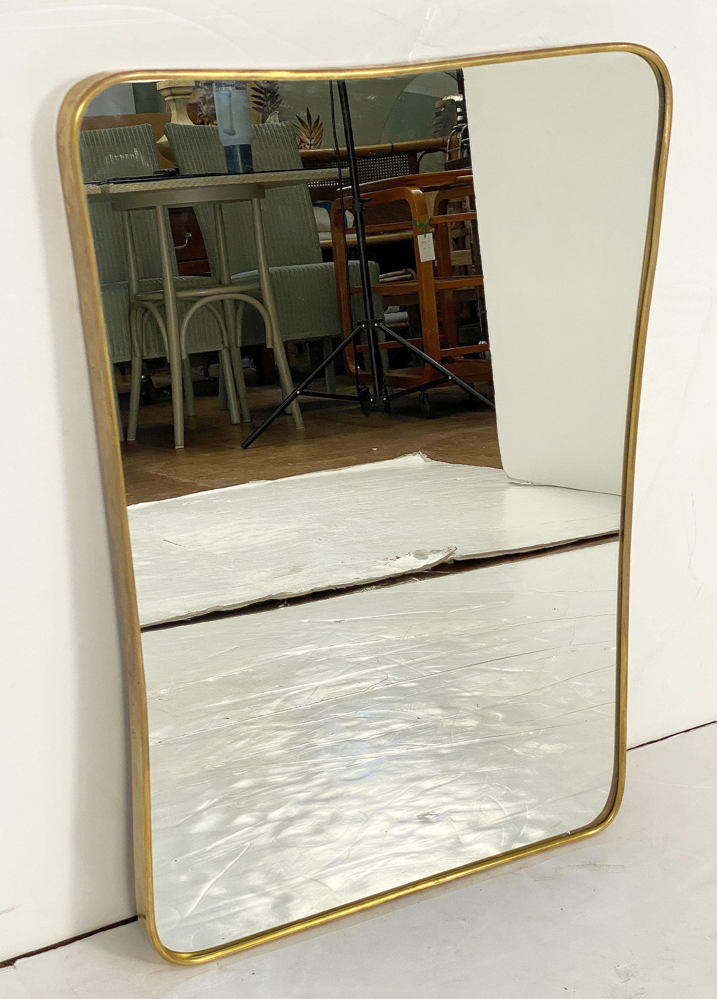 Ce beau miroir mural italien moderne présente un design épuré du milieu du siècle et un élégant cadre incurvé en laiton, dans le style du célèbre designer Gio Ponti. (Italien, 1891-1979)

Architecte, designer industriel et de mobilier et éditeur,