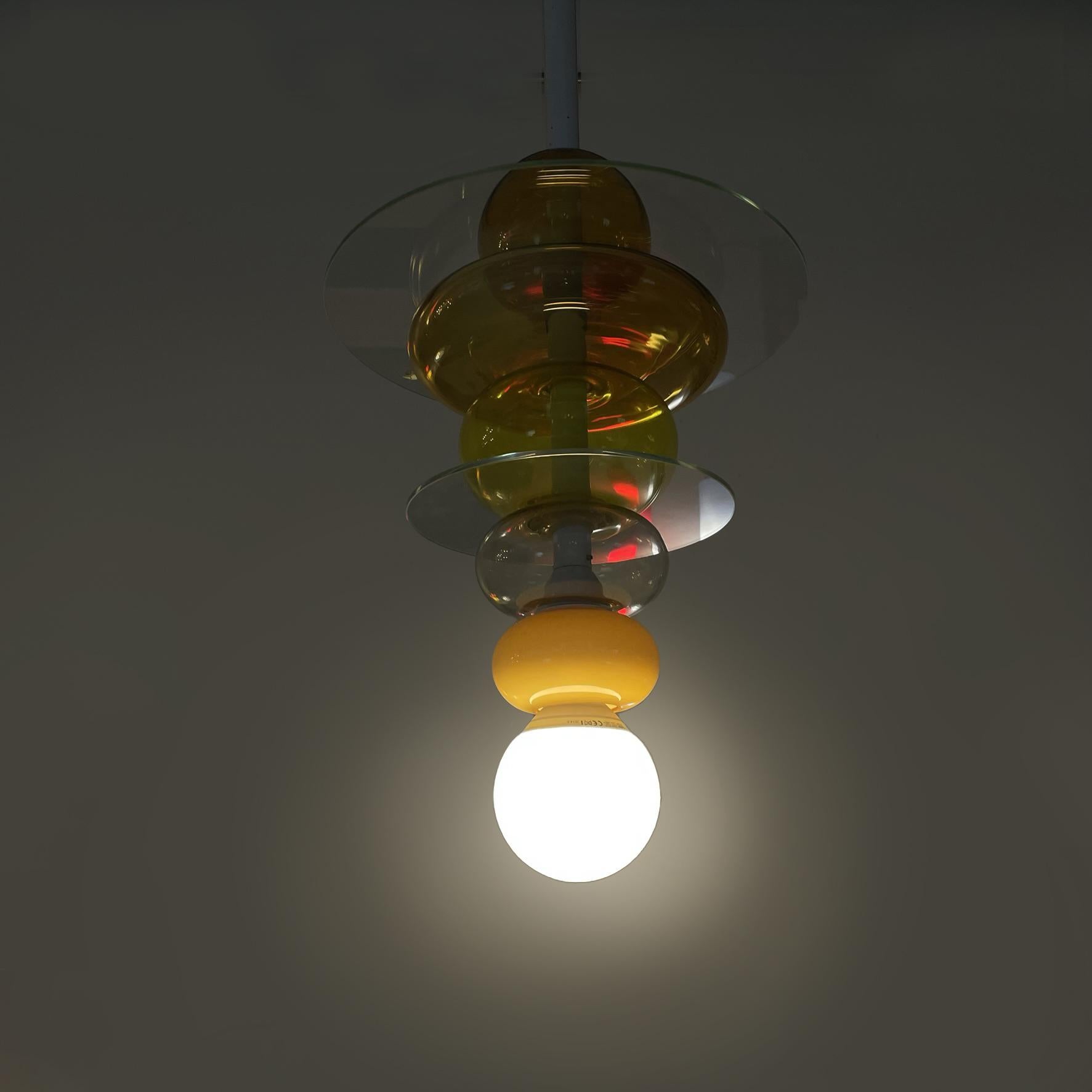 Italian modern glass chandelier Firenze by Ettore Sottsass for Venini, 1990s
Chandelier mod. Firenze (Florence) composed of a series of transparent and yellow glass spheres, interspersed with round glass discs. Structure in white painted metal.
It