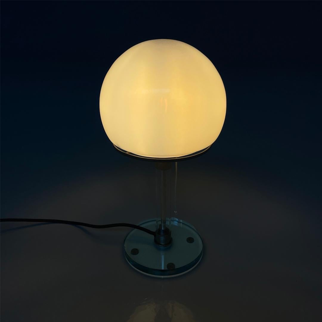 Lampe de table moderne italienne en verre et métal WG 24 Wilhelm Wagenfeld Tecnolumen, années 1980
Lampe de table modèle WG 24 avec base ronde. La structure est composée d'une tige tubulaire en verre transparent et en métal et d'une base en forme de