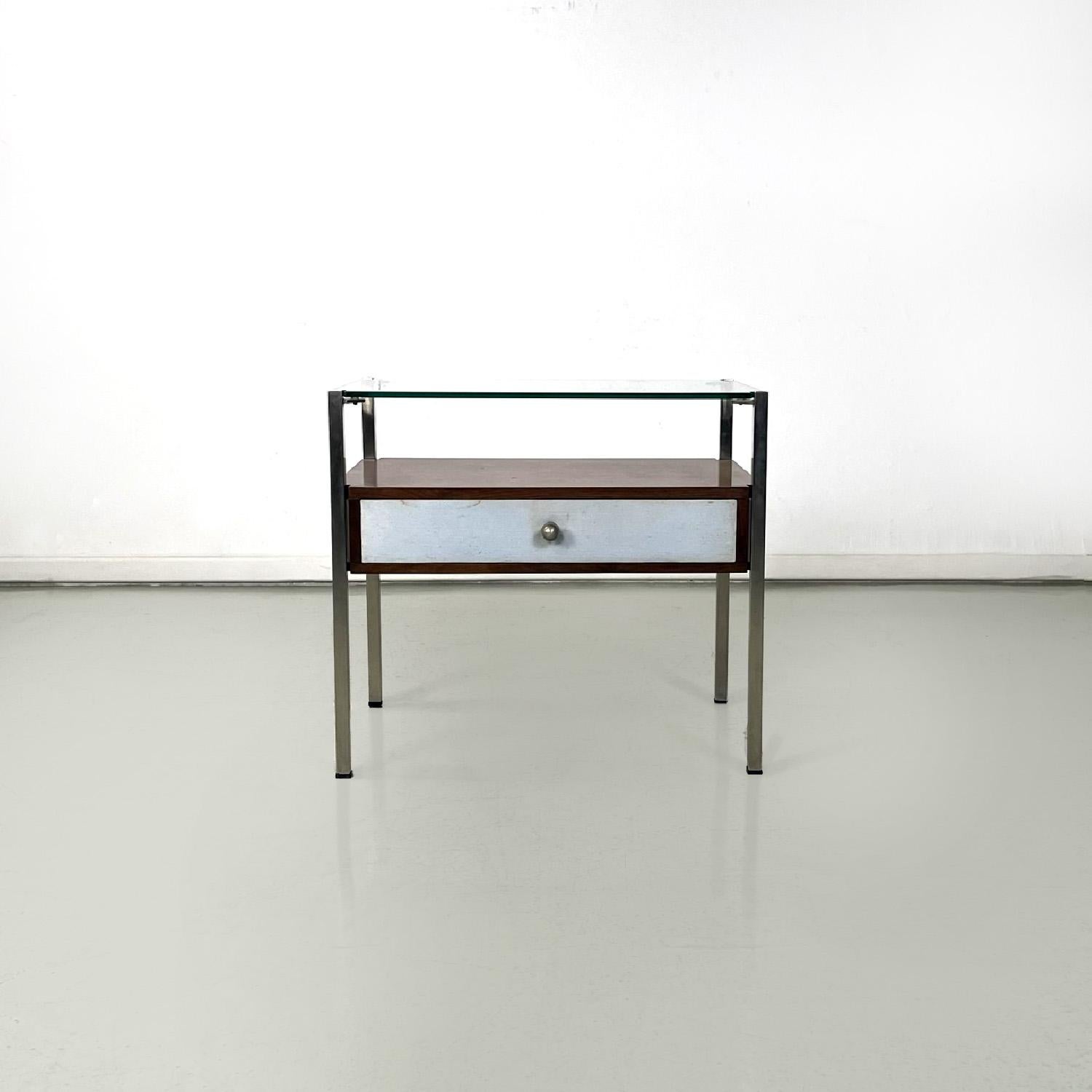 Italian modern glass metal wood and light blue fabric bedside tables, 1970s
Pair of rectangular bedside tables. The structure is made of metal with a square section, the upper surface is made of glass. The lower shelf is a wooden structure with a