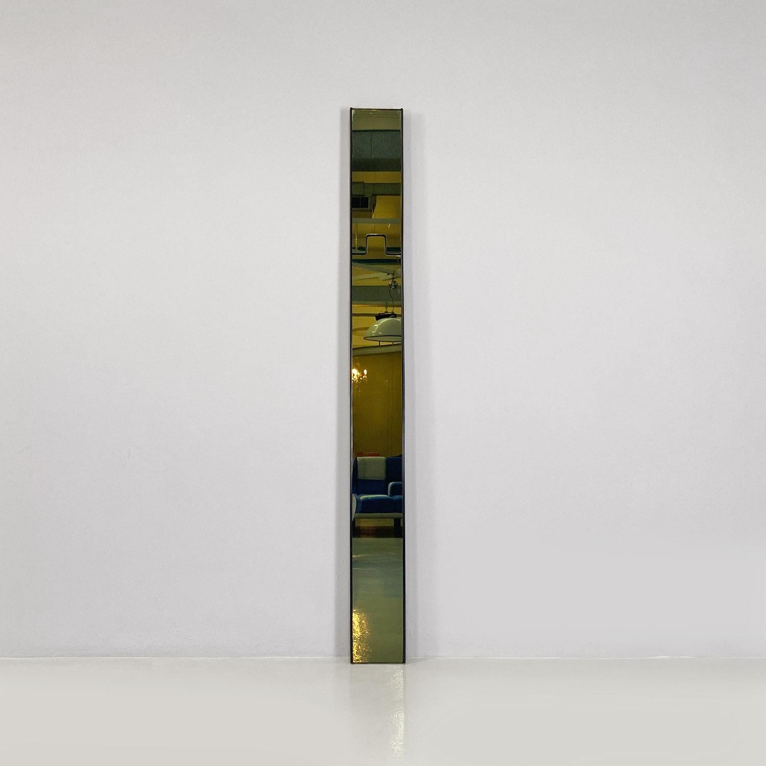 Miroir mural modèle Gronda composé de quatre modules rectangulaires en verre fumé, avec structure d'encadrement en plastique noir. La particularité de ce miroir est qu'il dispose d'un crochet rétractable, qui peut être utilisé comme portemanteau.